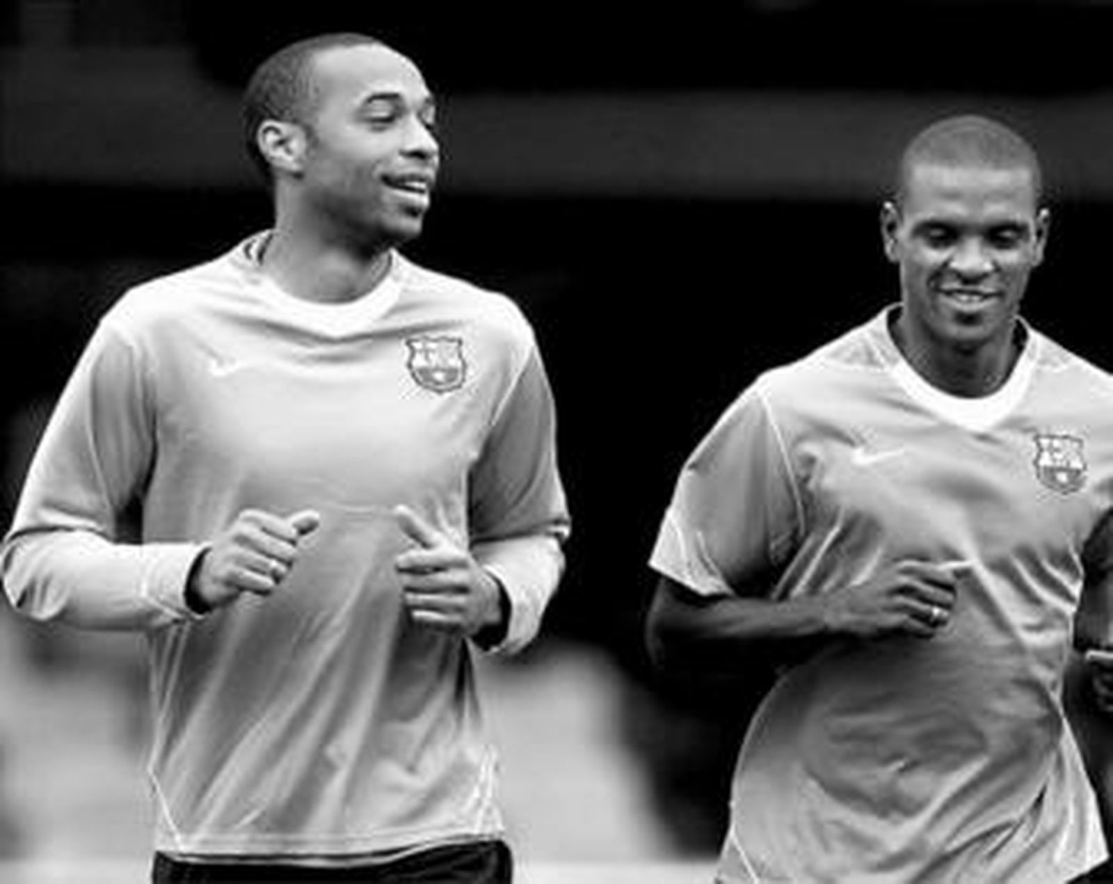 Henry corre junto a su compatriota Abidal durante un entrenamiento del Barcelona en La Masía.