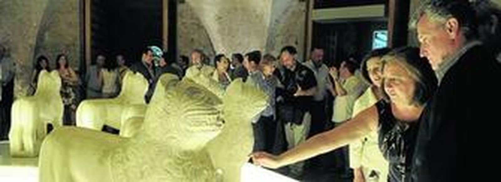 La directora del Patronato de la Alhambra y el Generalife, María del Mar Villafranca, y el consejero de Cultura, Paulino Plata, observan la exposición de los leones restaurados en el Carlos V.