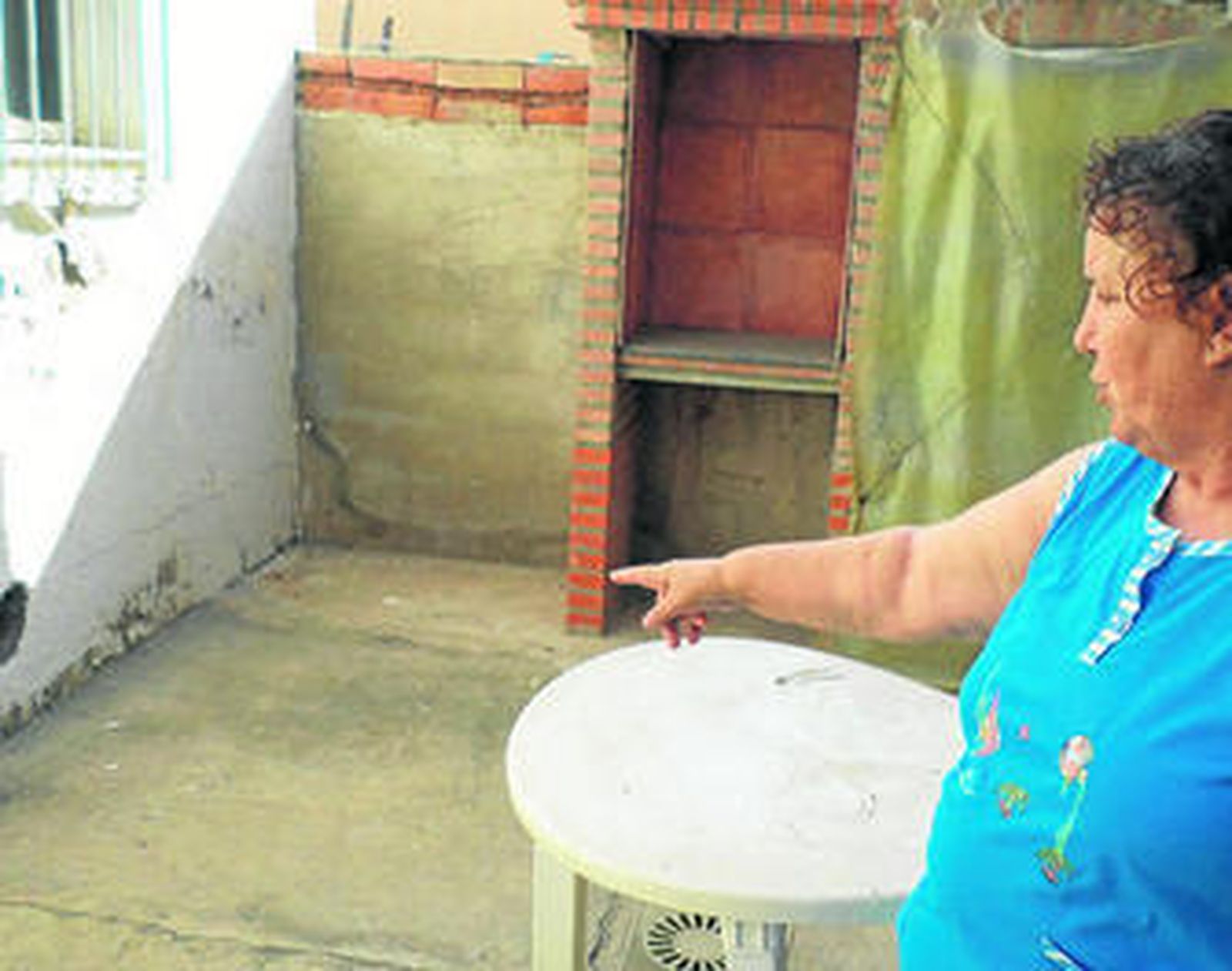 Encarnación Yebra muestra las humedades que presenta su casa en el patio.