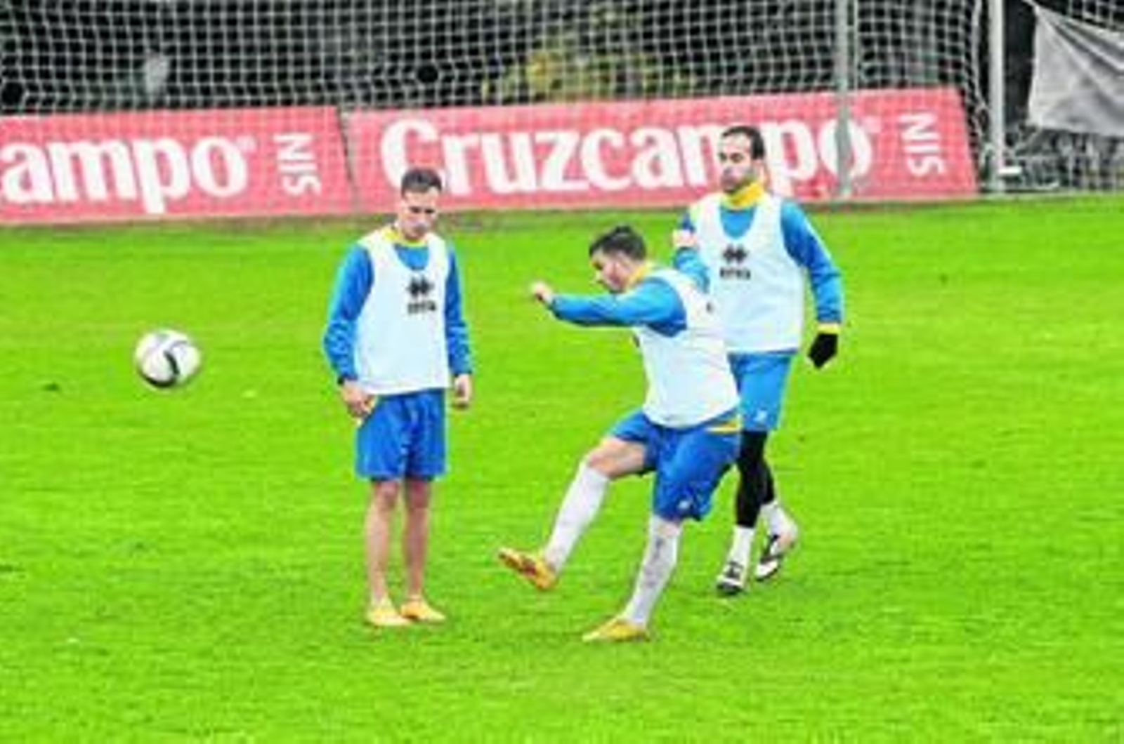 Kike López golpea el balón en presencia de Migue García y Andrés Sánchez.