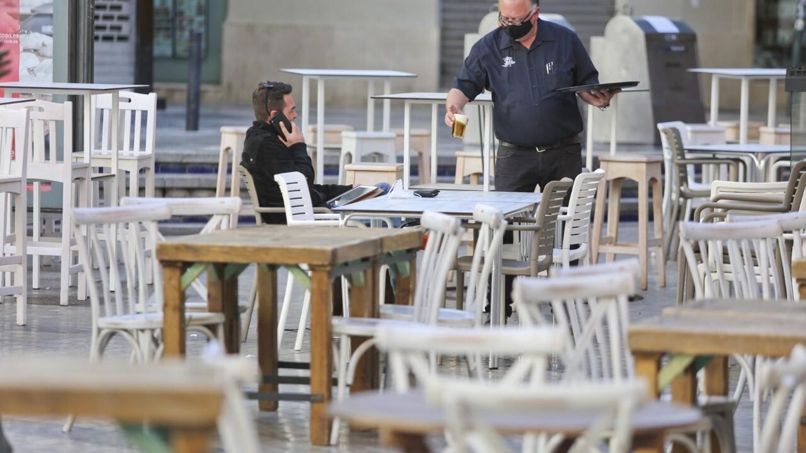 Un camarero atiende a un cliente en el centro de Málaga.