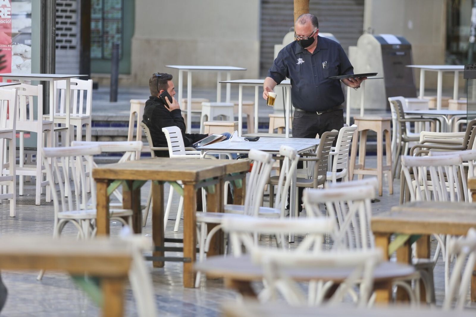 Un camarero atiende a un cliente en el centro de Málaga.