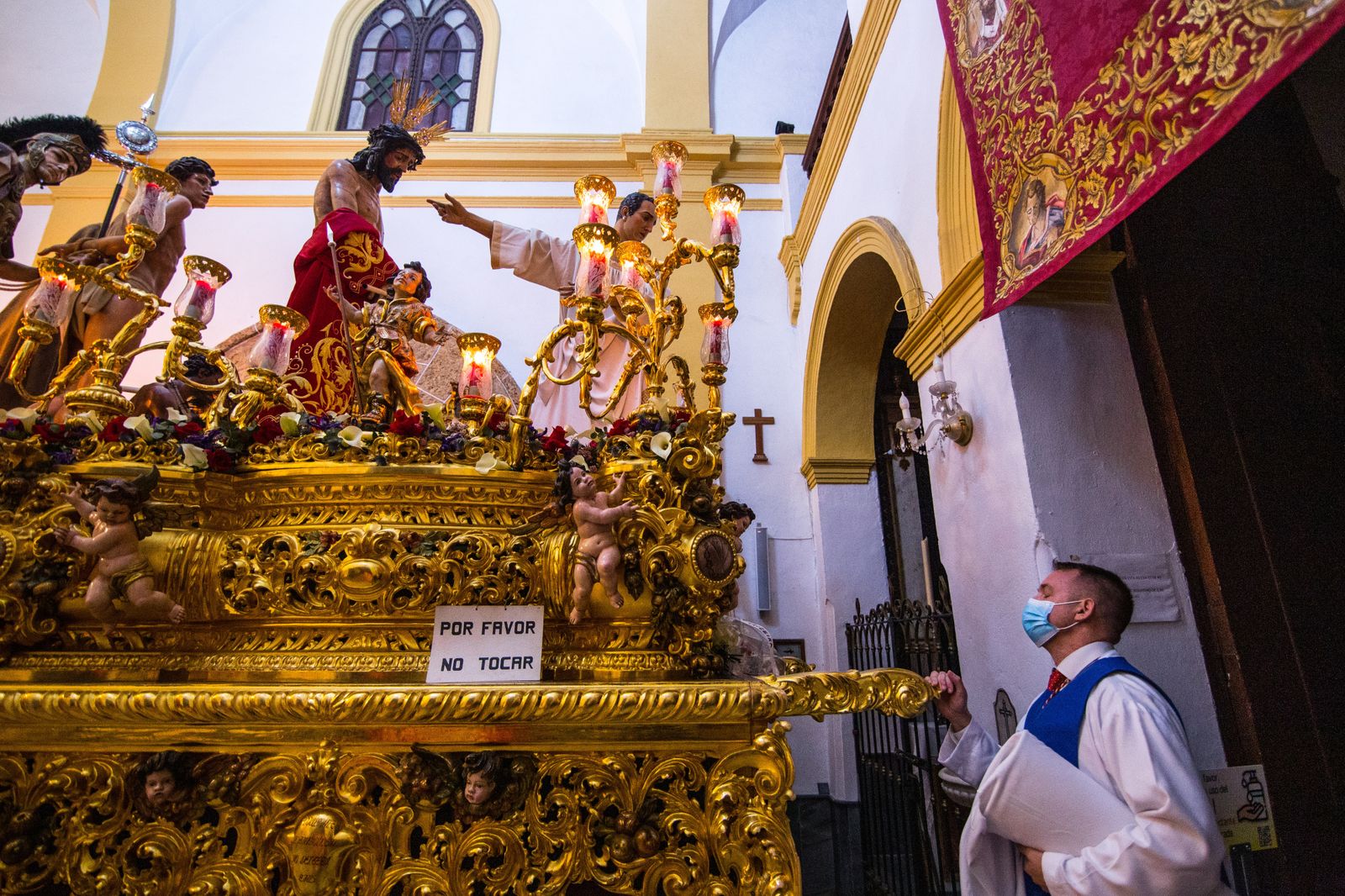 Un hermano del Ecce Homo contempla a su titular en el paso tras conocerse la suspensión de la salida procesional.