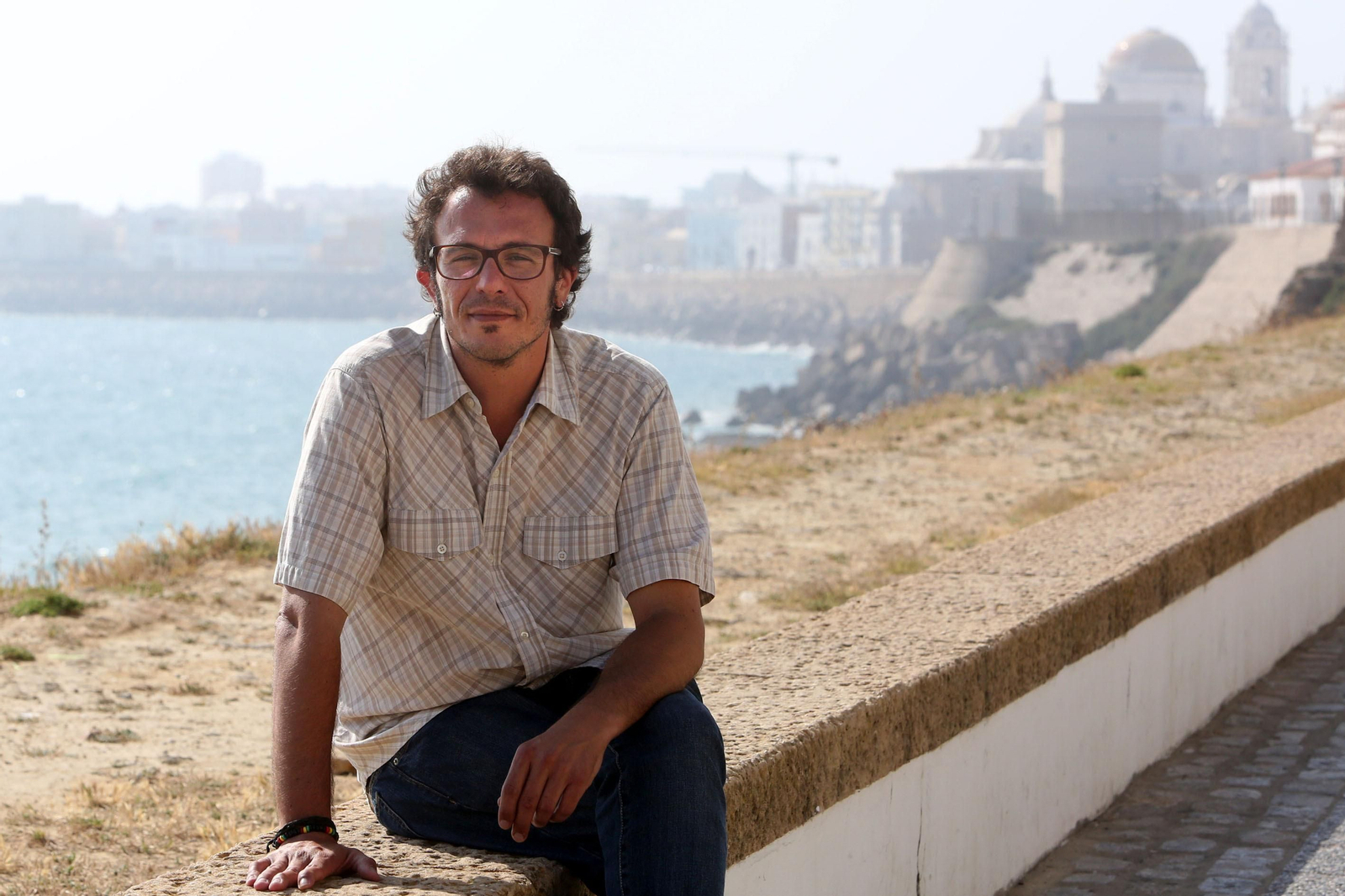 El alcalde, sentado en la balaustrada del primer tramo del Paseo Marítimo, el Malecón de Cádiz