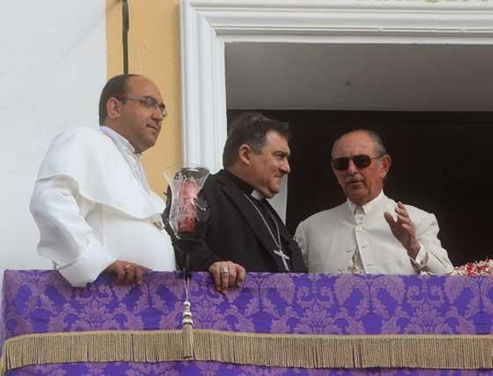 El padre Alexis, el obispo José Mazuelos y el hermano mayor de la Hermandad de Jerez, Felipe Morenés, en el balcón de la casa. 

Foto: Juan Carlos Toro
