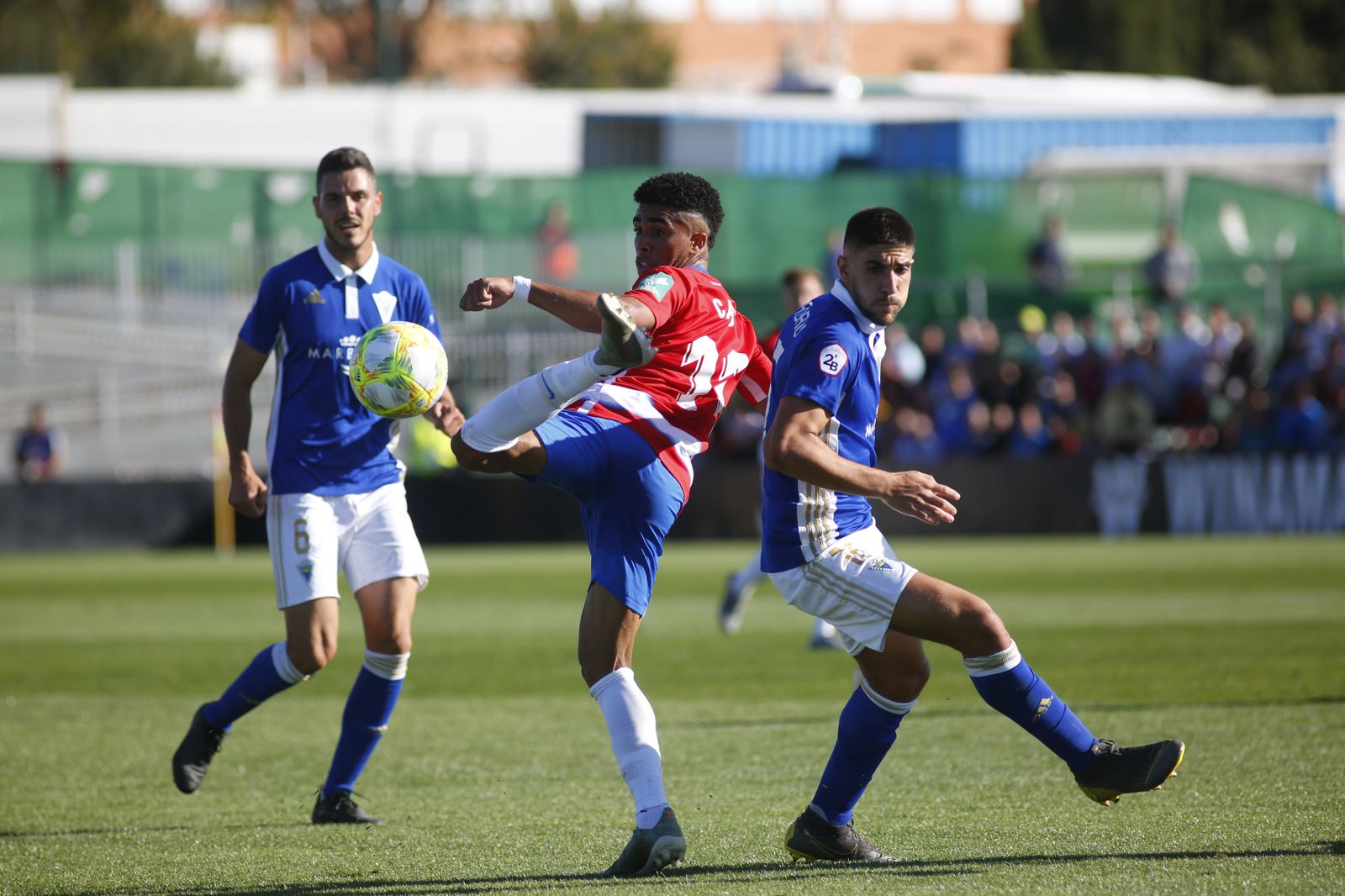 Caio controla el balón ante dos rivales