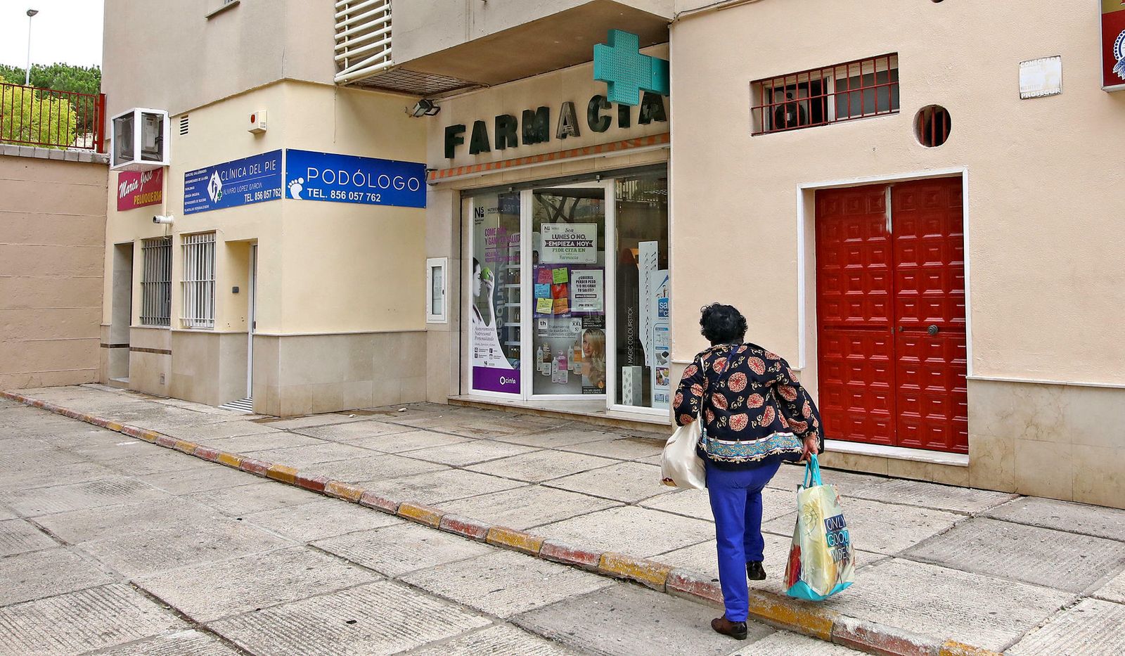 Una señora camina junto a la farmacia en la que pusieron una pistola en el estómago a la farmacéutica.