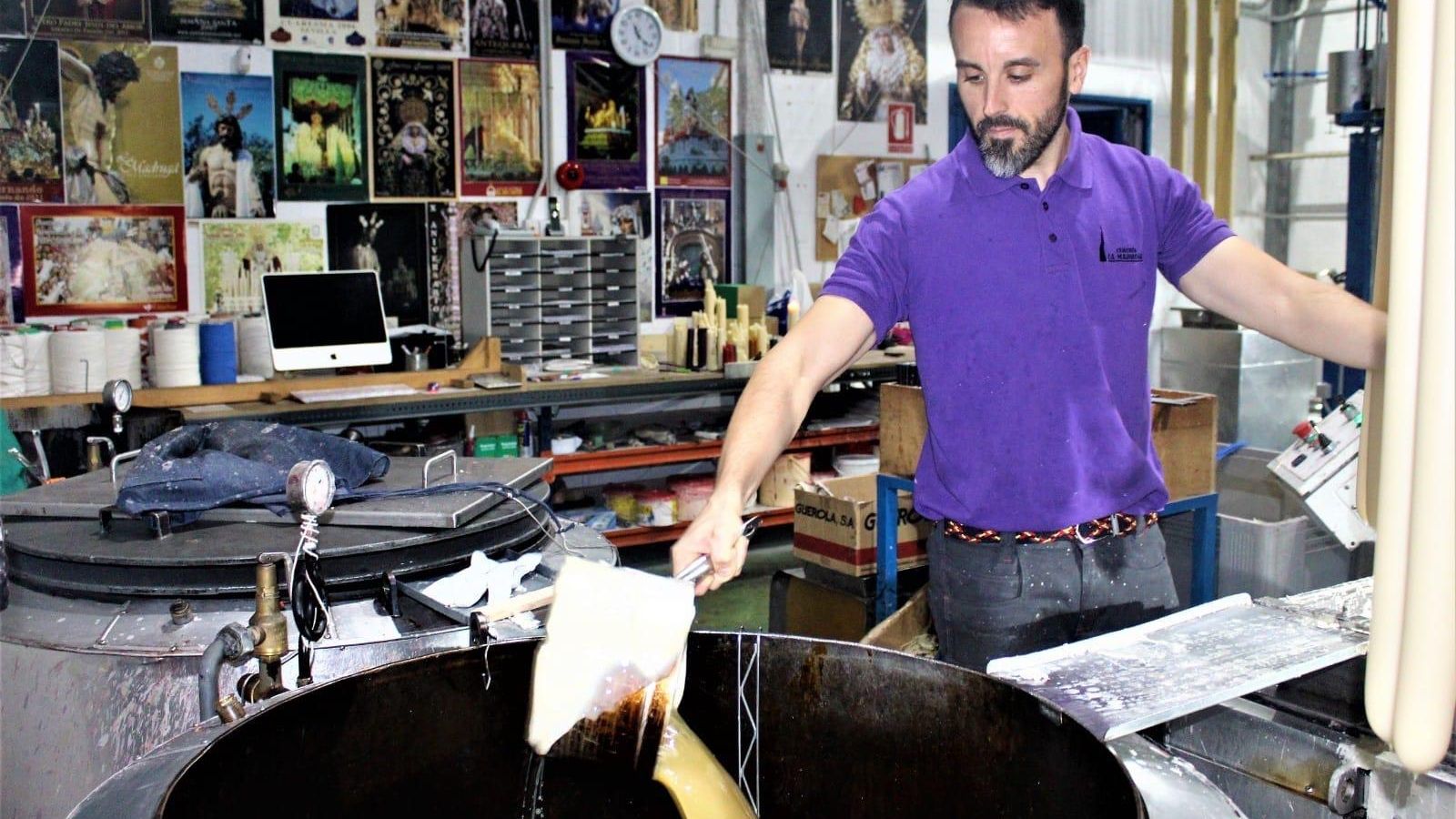 Un trabajador de la Cerería La Madruga sacando cera caliente para formar las velas