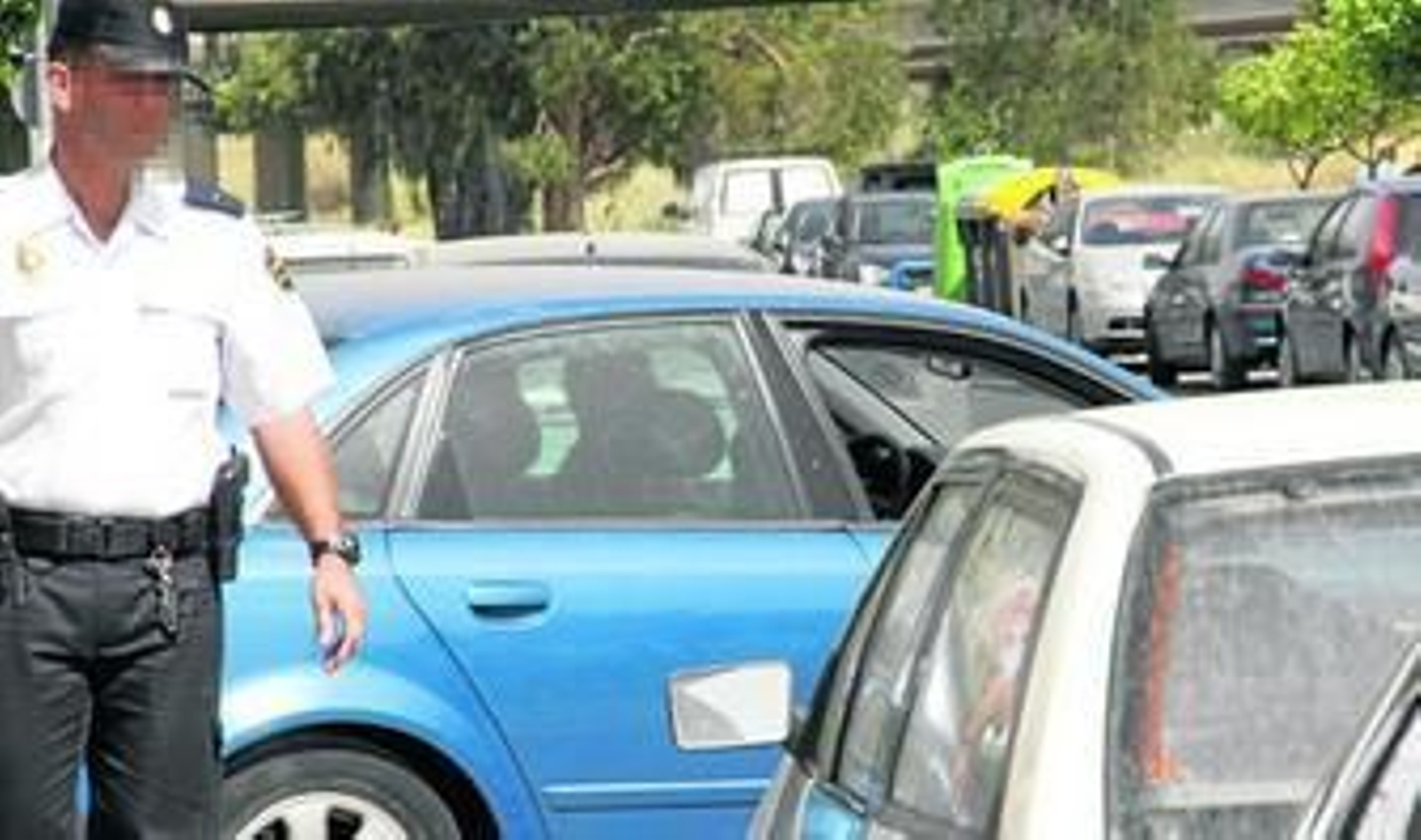 Un agente de la Policía Nacional vigila la salida del juzgado en coche de uno de los presuntos autores del ataque a una menor en Isla Cristina.