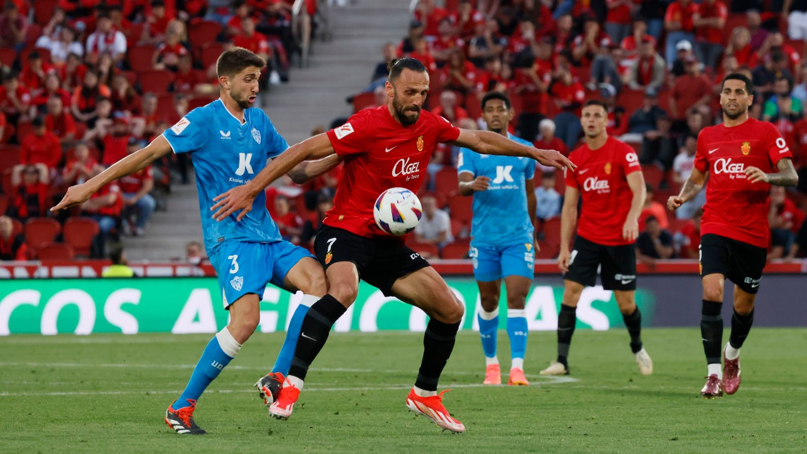 Édgar y Muriqi pugnan por un esférico en posesión del delantero.
