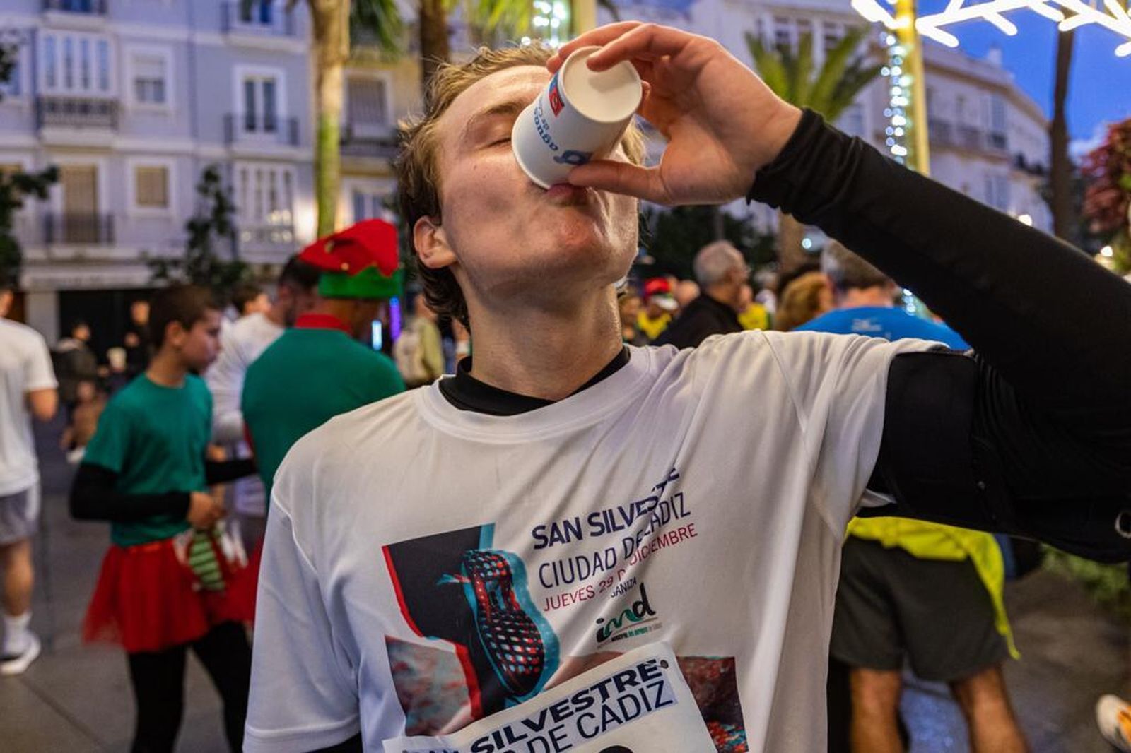 Un corredor bebe agua tras terminar la carrera.