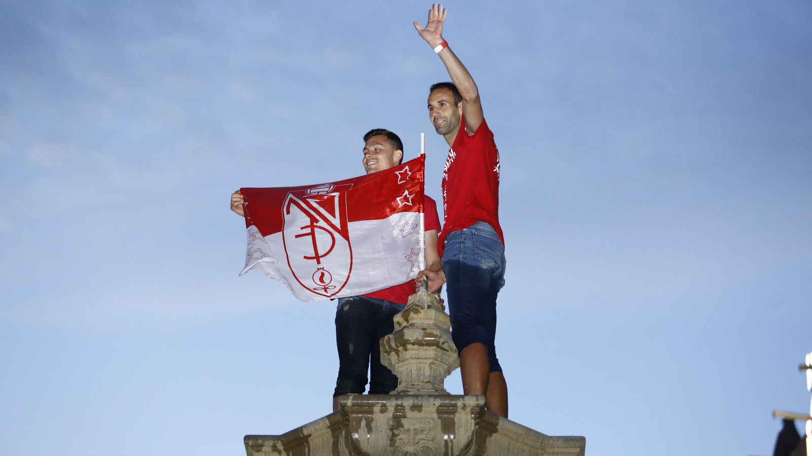 Victor Díaz y Alberto Martín, con la bandera del Granada en lo alto de la Fuente de las Batallas