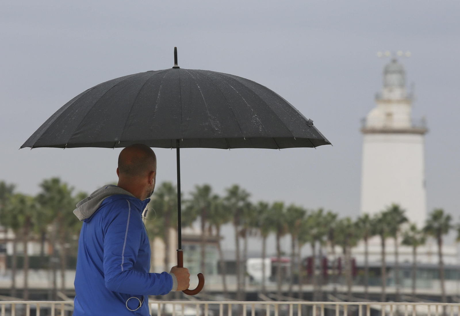 Un hombre se protege con un paraguas de la lluvia en Málaga.