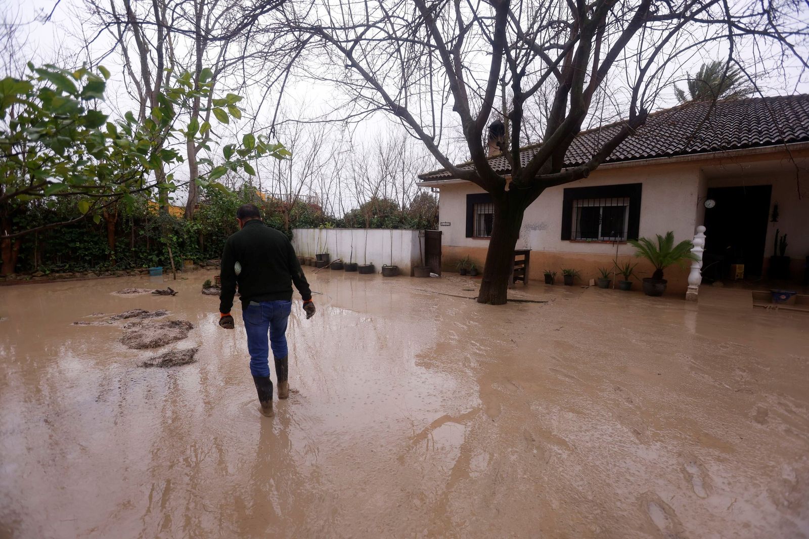 Un vecino entra en su vivienda, afectada por las inundaciones en Córdoba.