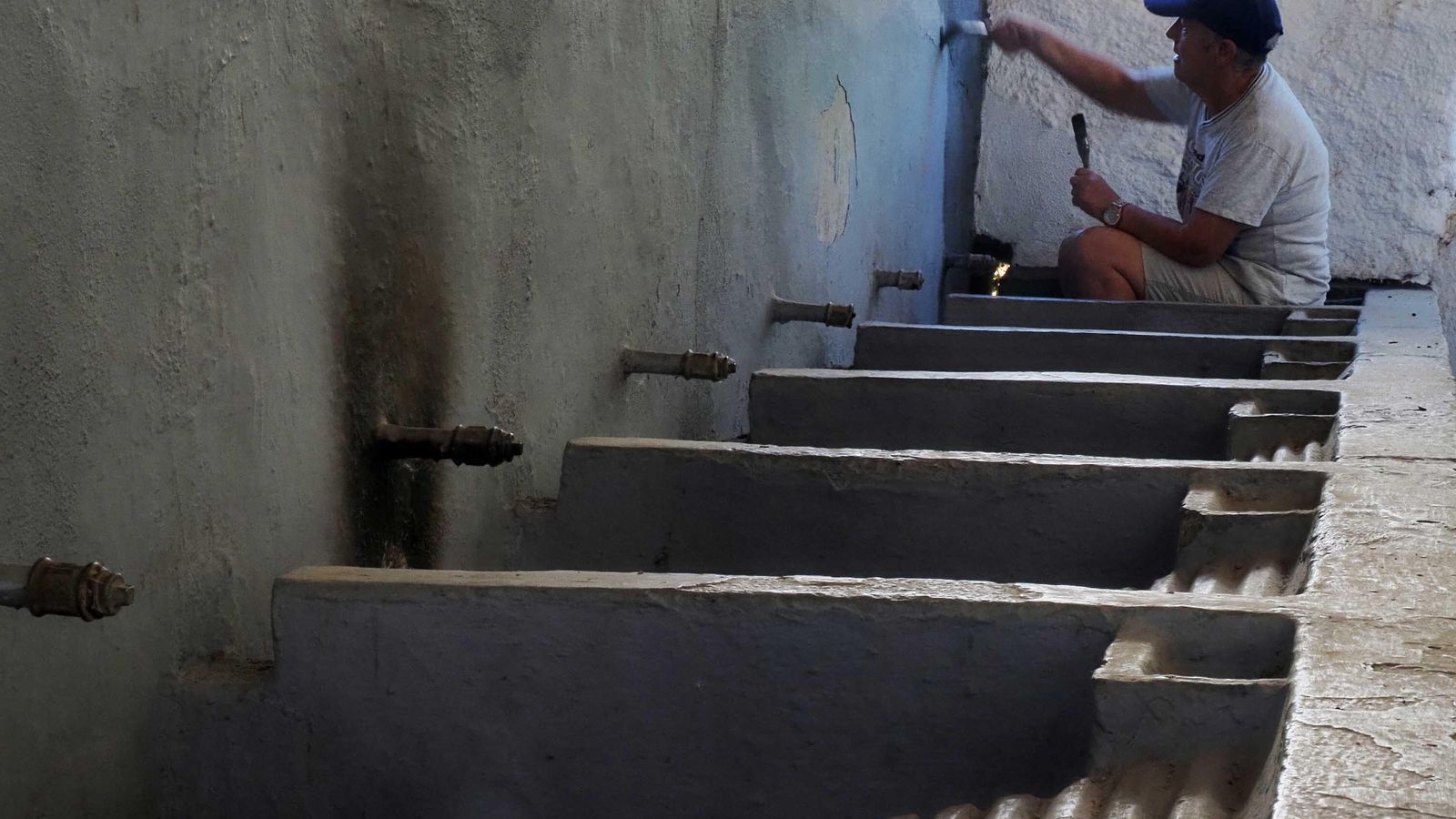 Una empleada municipal realiza labores de mantenimiento en los antiguos lavaderos municipales de Cortelazor