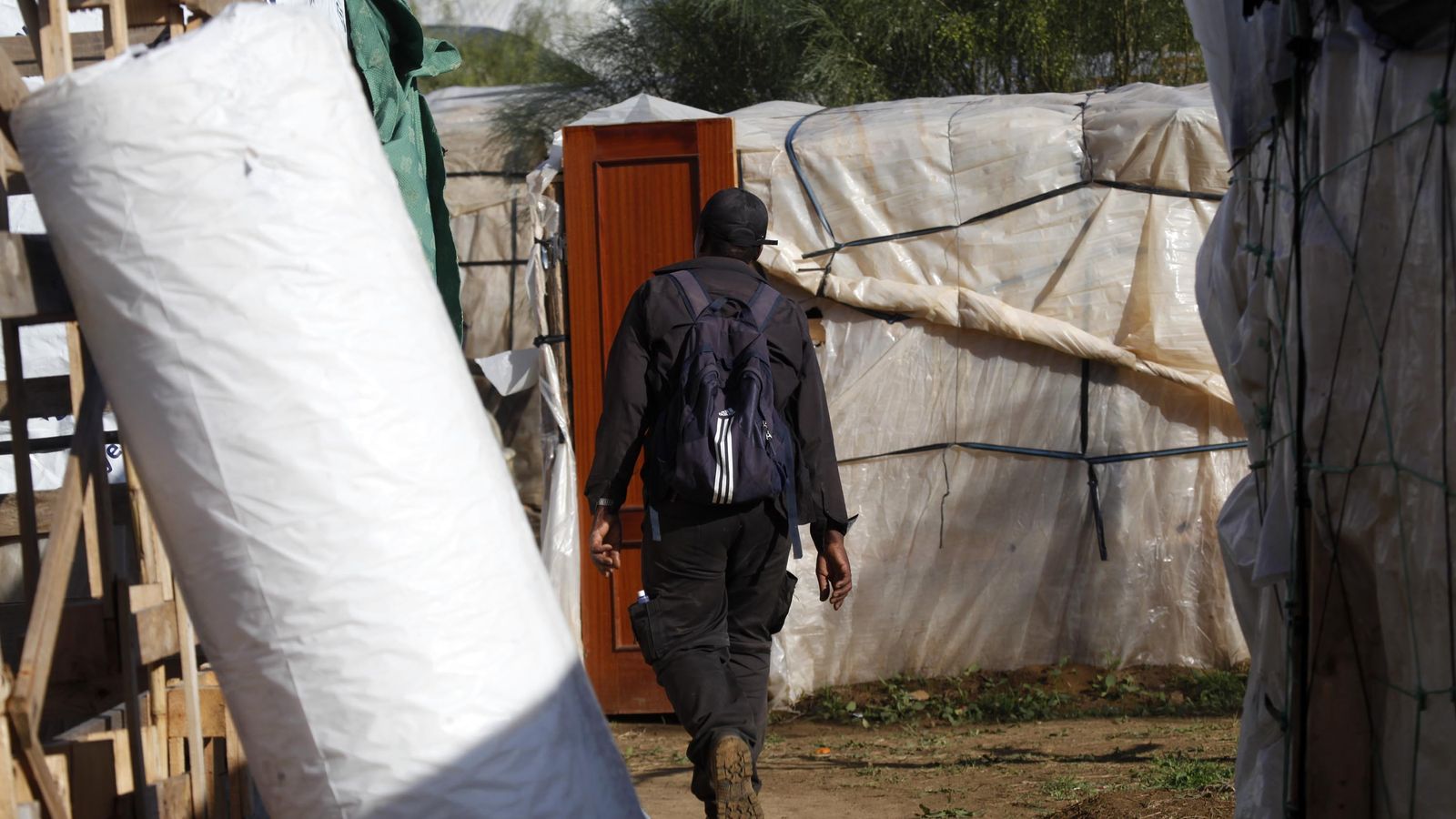 Un inmigrante camina entre chabolas de plástico en uno de los asentamientos de Huelva, en una imagen de archivo