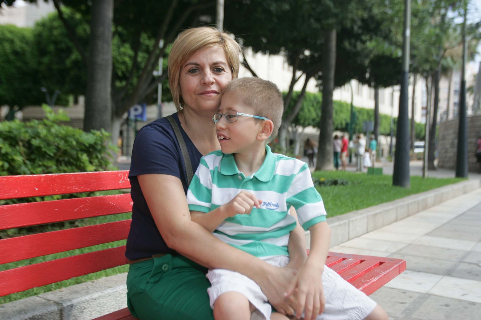 Loli y su pequeño Fran sentados en un banco de la Rambla de la capital.