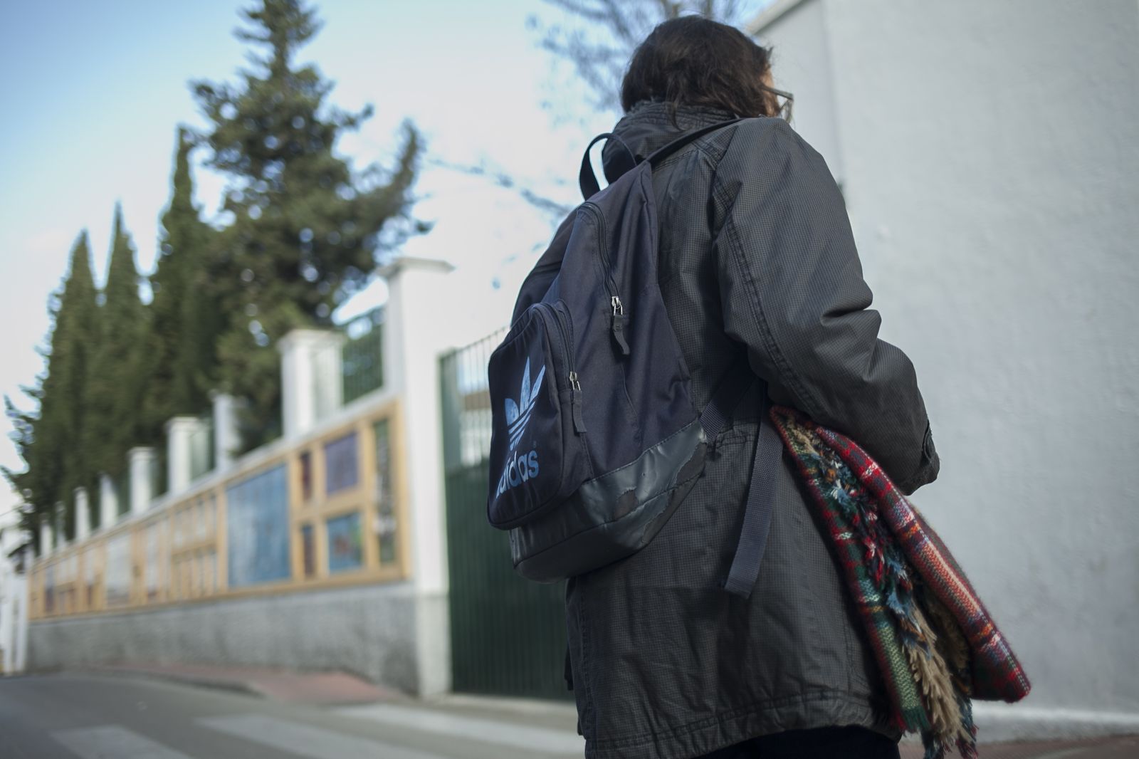 Una alumna se dirige al instituto con su abrigo y una manta.