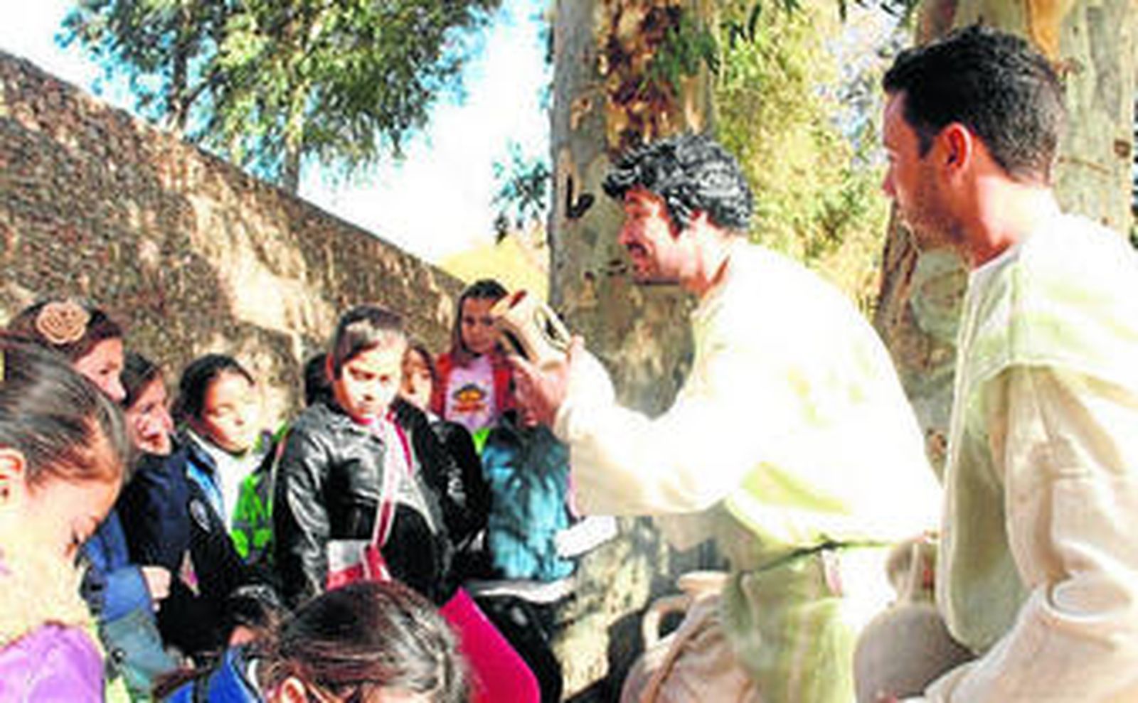 Actores ataviados con indumentaria romana enseñan un ánfora.