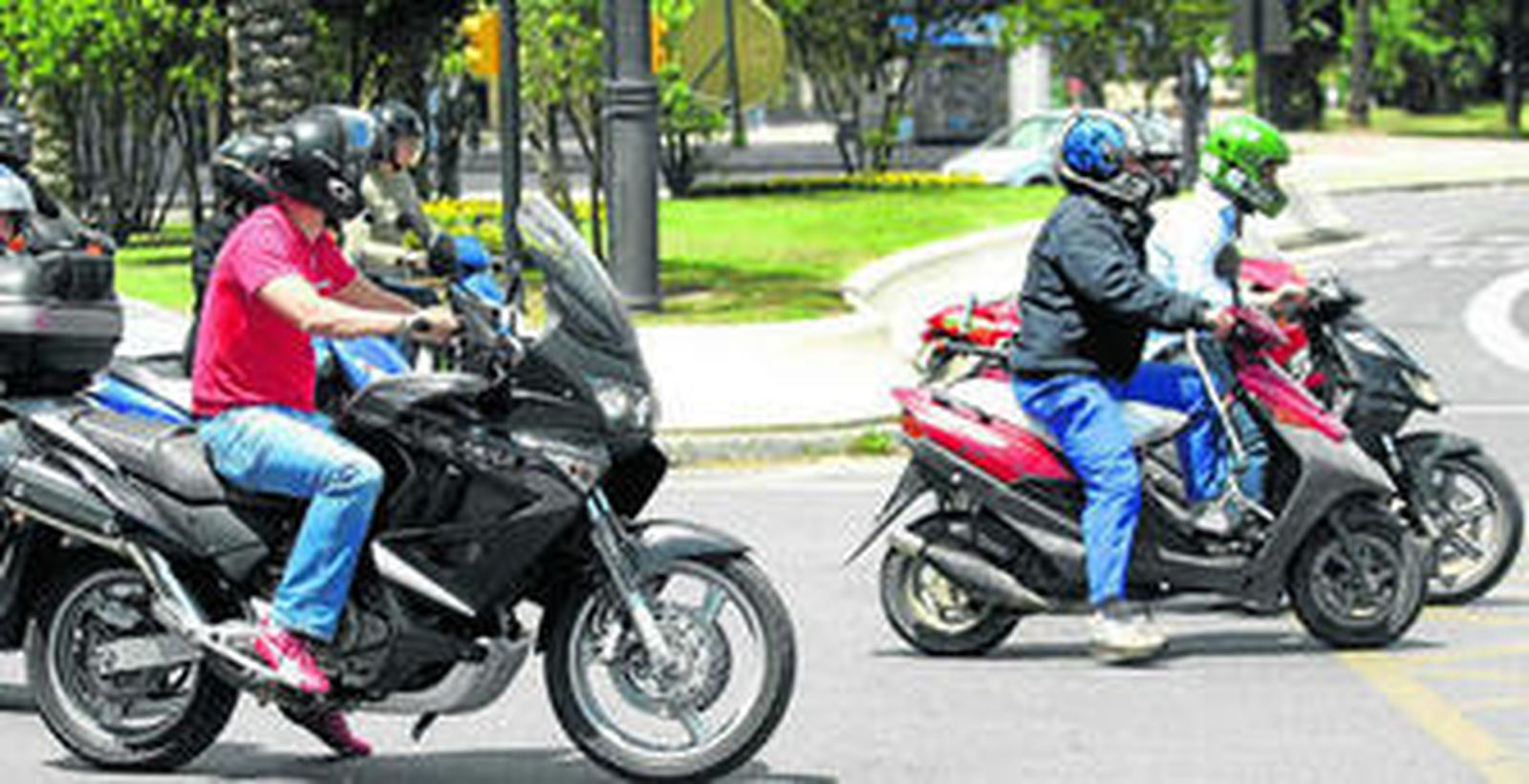 Un grupo de motoristas espera en un semáforo de la capital.