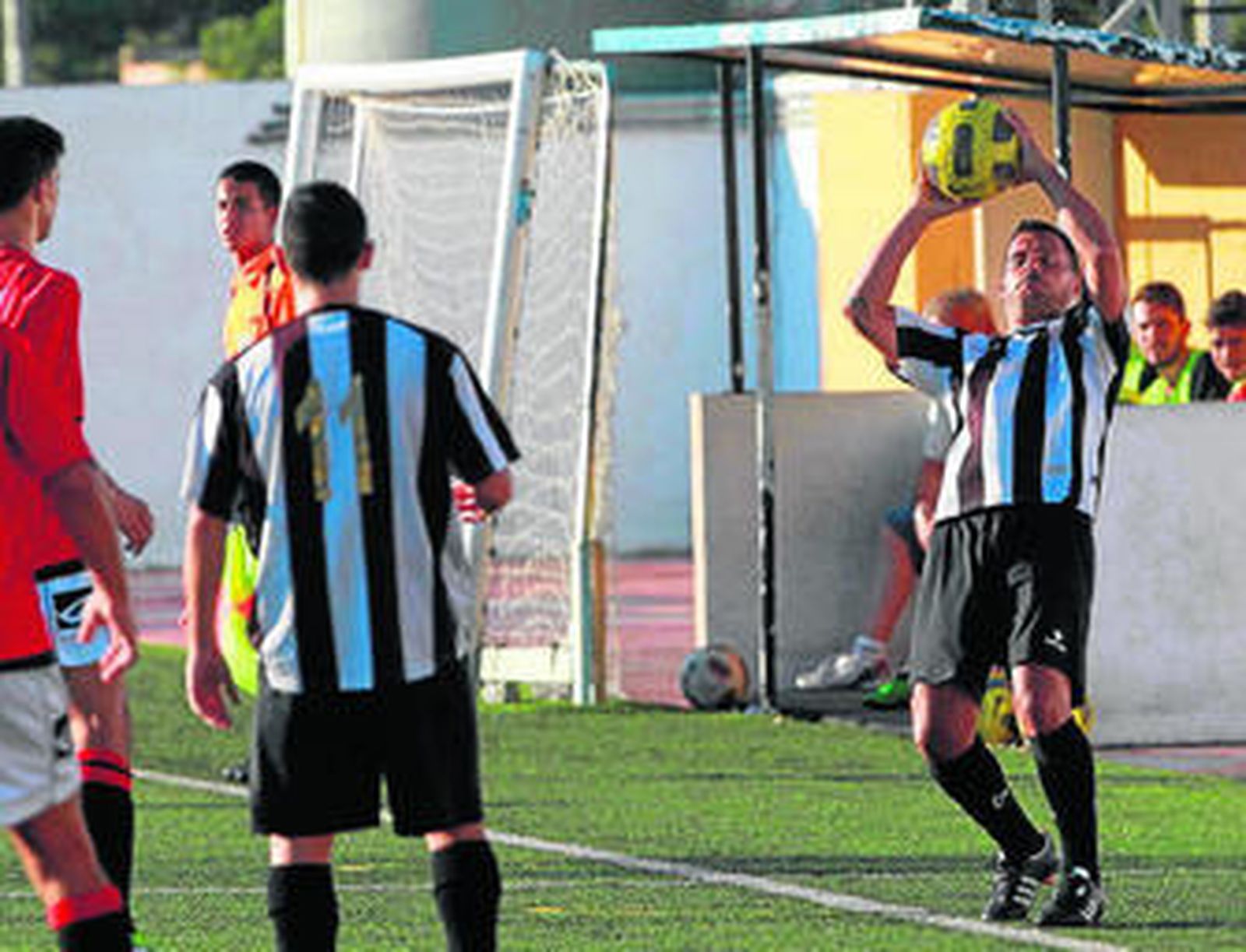 Un jugador del Athletic Nueva Jarilla saca de banda en un lance de un partido.