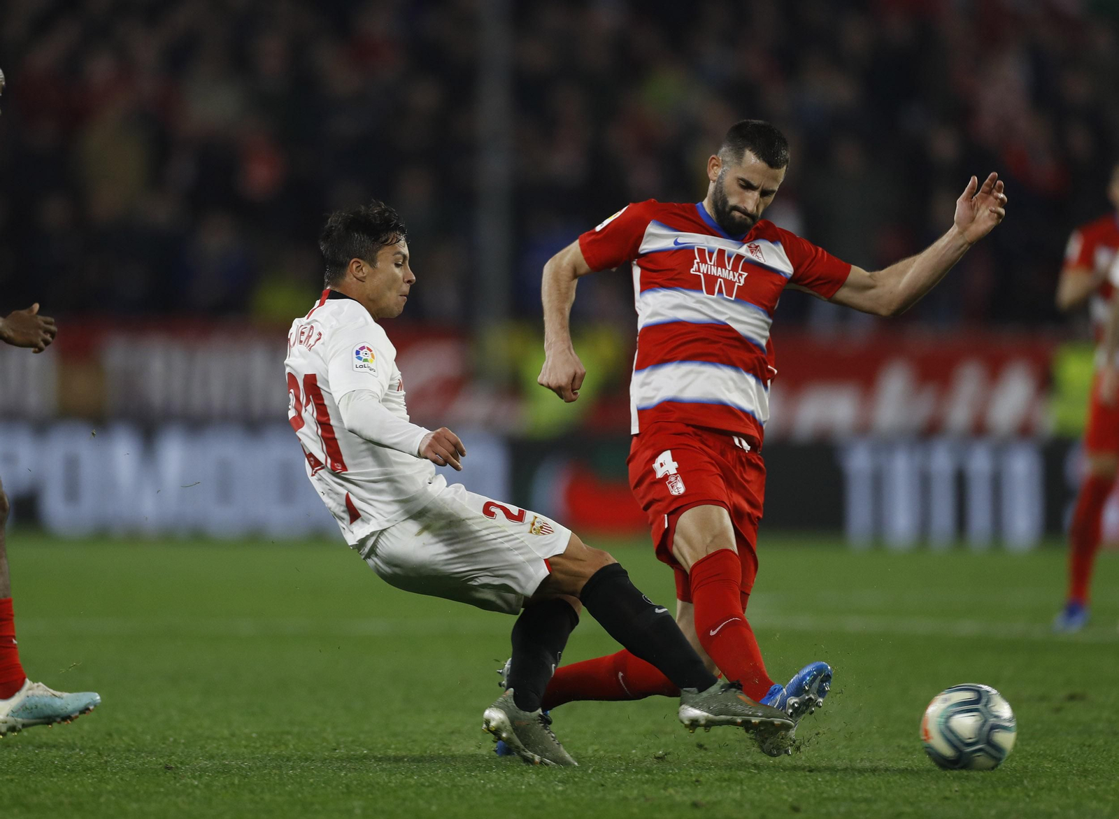 Óliver Torres logra conectar el pase pese a la entrada de Gonalons en el Sevilla-Granada.