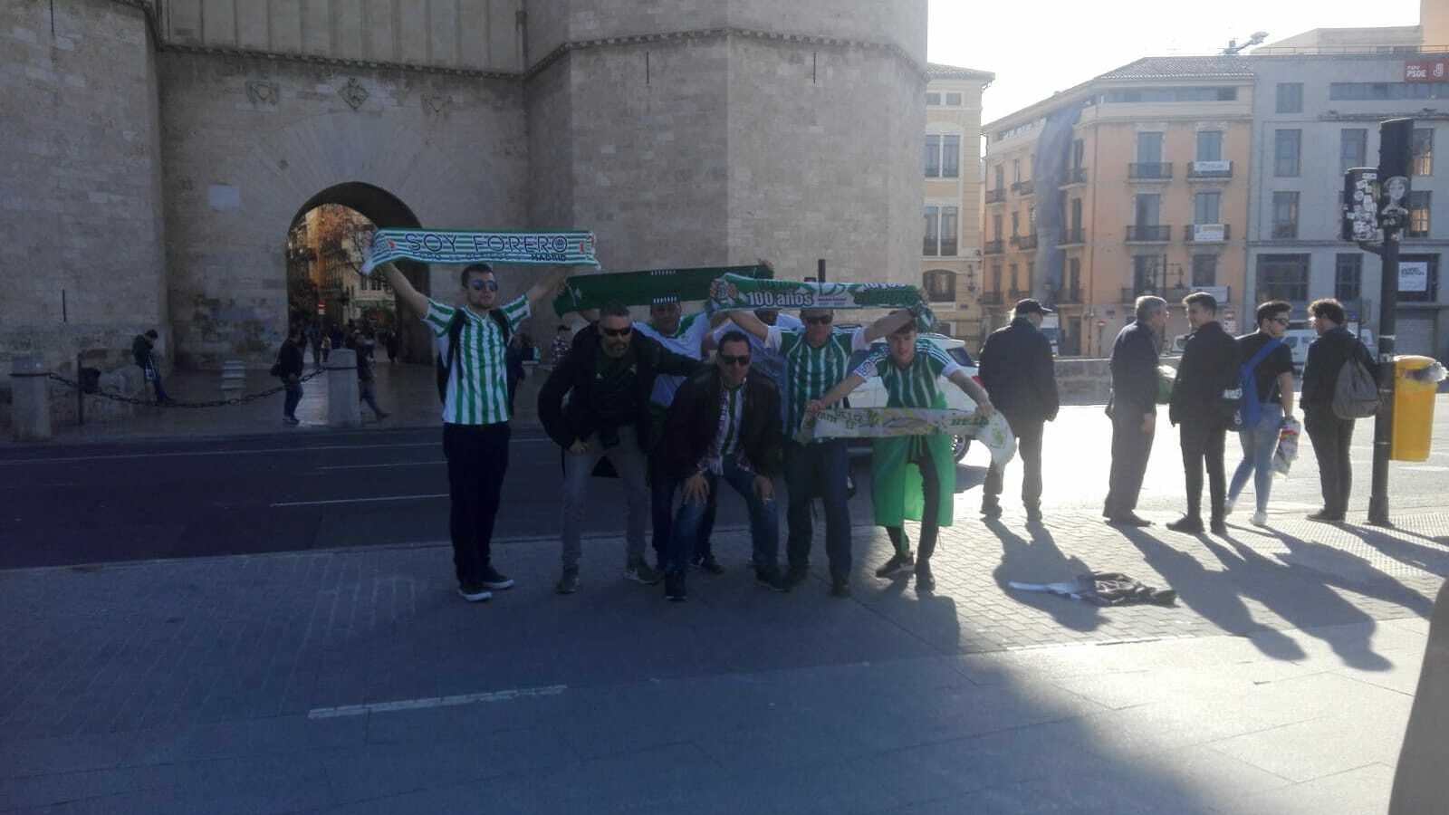 Aficionados béticos exhiben sus símbolos ante las Torres de los Serranos, en Valencia.