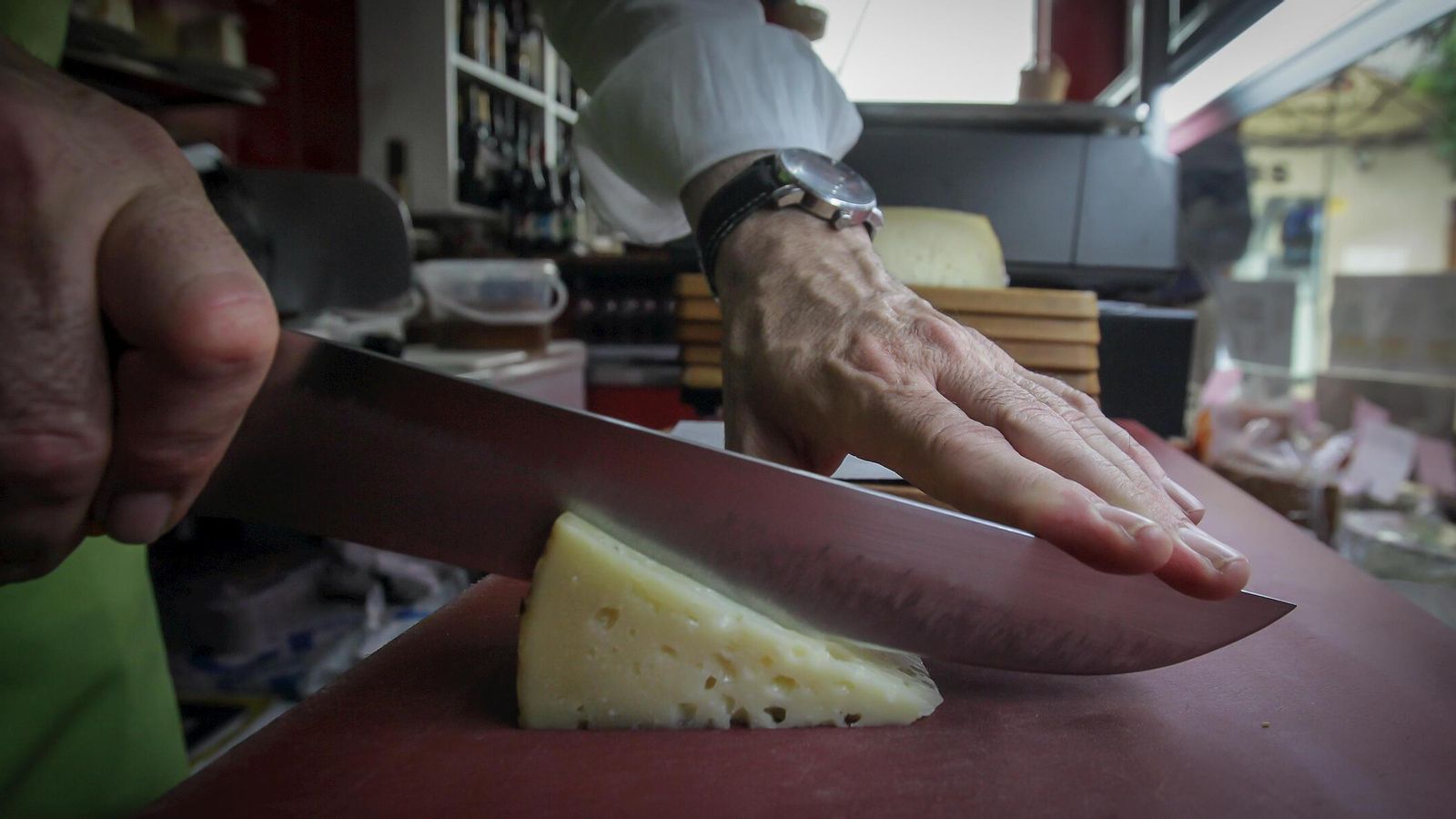 Juan Manuel Vega cortando cuñas de un queso de oveja de Zamora metido en manteca de chicharrón con especias.