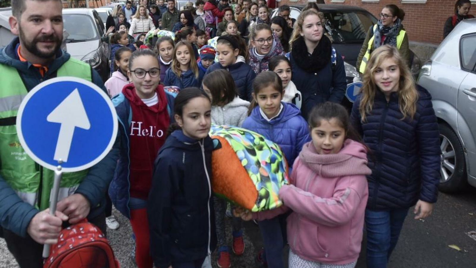 Los menores junto a la serpiente Travis, con los voluntarios portando las señales de tráfico.