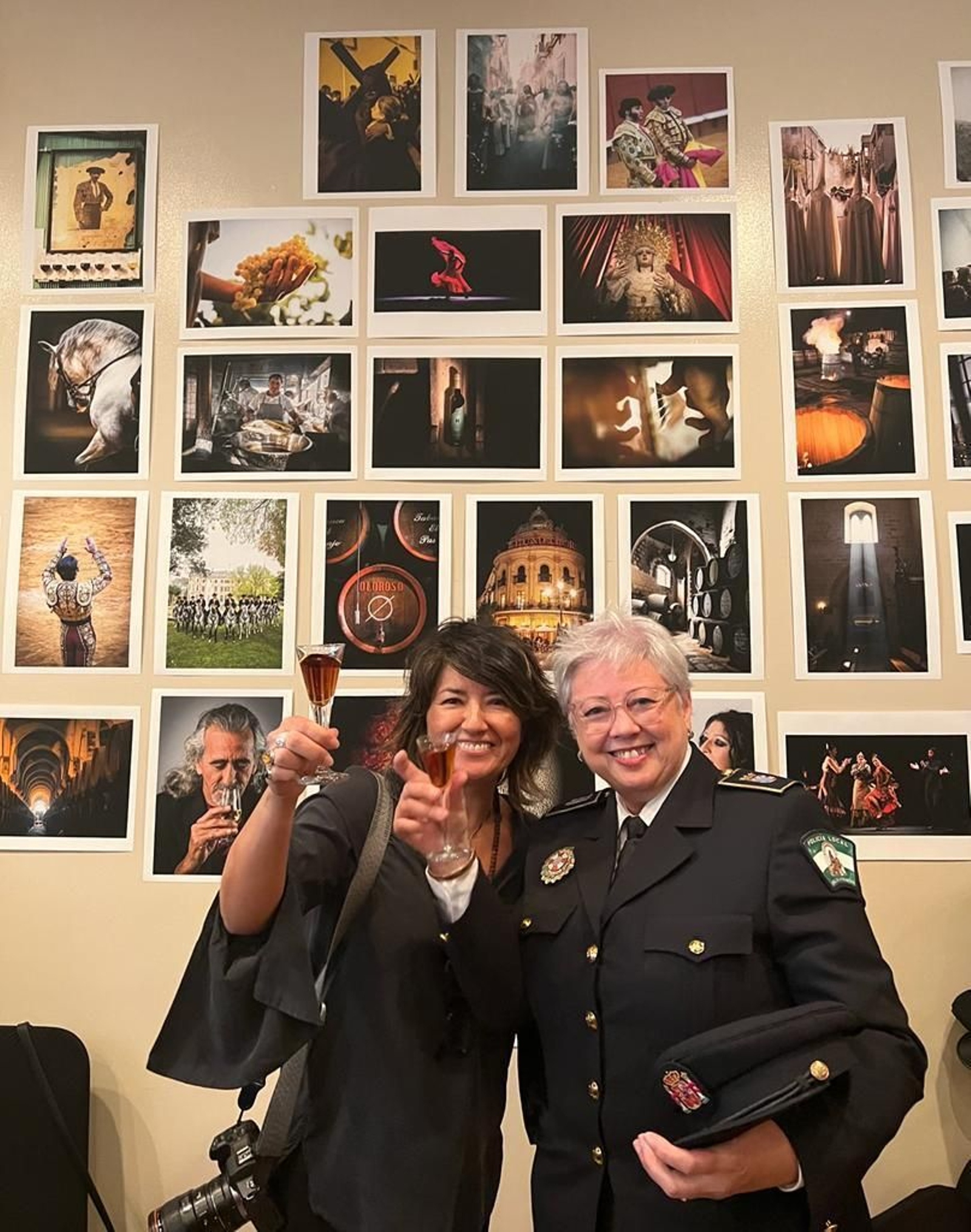 María Higuero y Mari Luz Rojo brindan en La Nacional delante de la exposición de imágenes de Jerez de Higuero.