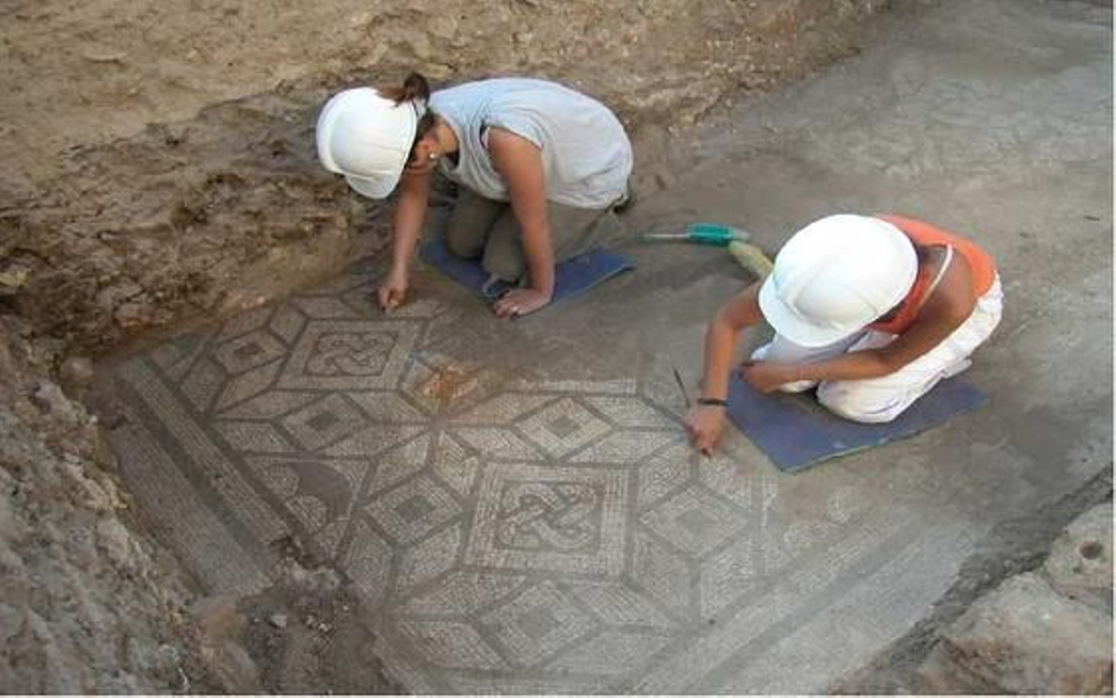 Trabajos de limpieza en uno de los mosaicos del Hospitium de los Delfines.

Foto: Diario de Sevilla