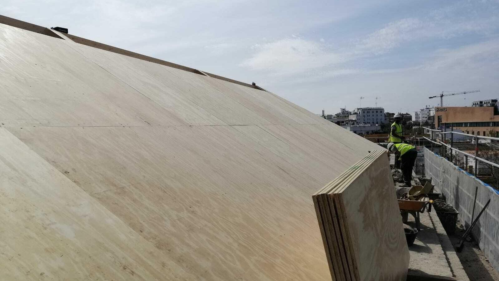 Un operario trabaja en la colocación de tablas en la cubierta del inmueble.