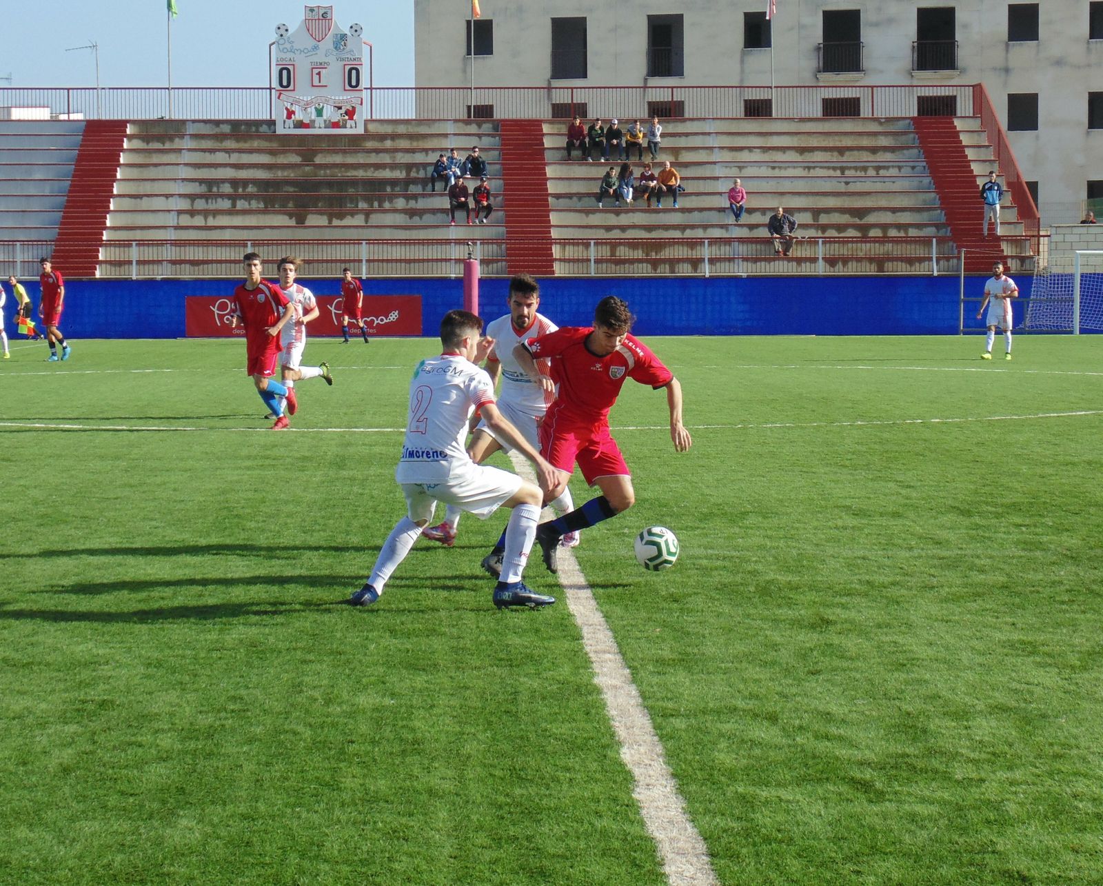 Los jugadores de la Palma Juanma y Pío tratan de robarle el balón a Sergio