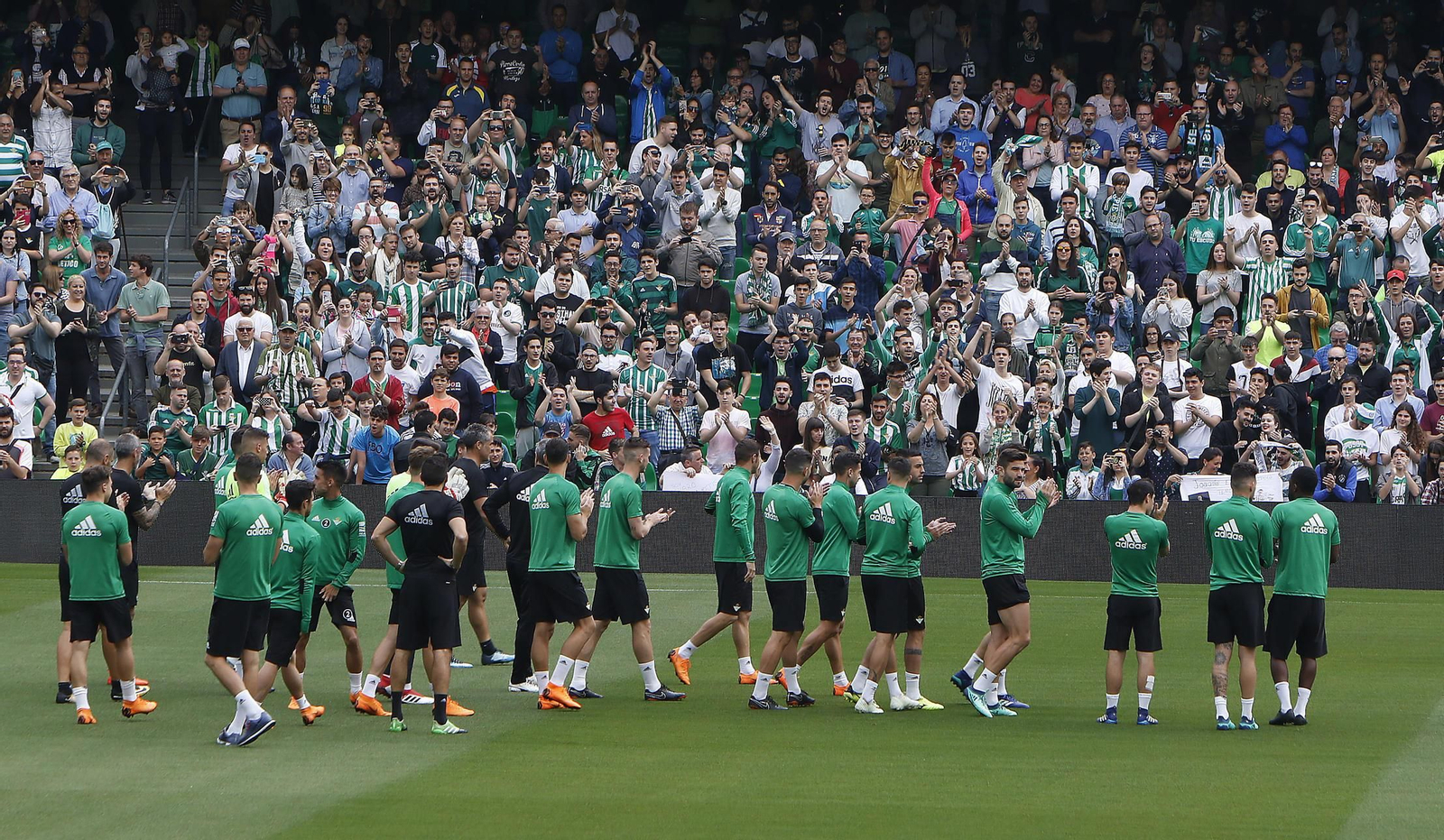 La plantilla del Betis y sus aficionados se aplauden mutuamente antes del entrenamiento bético.