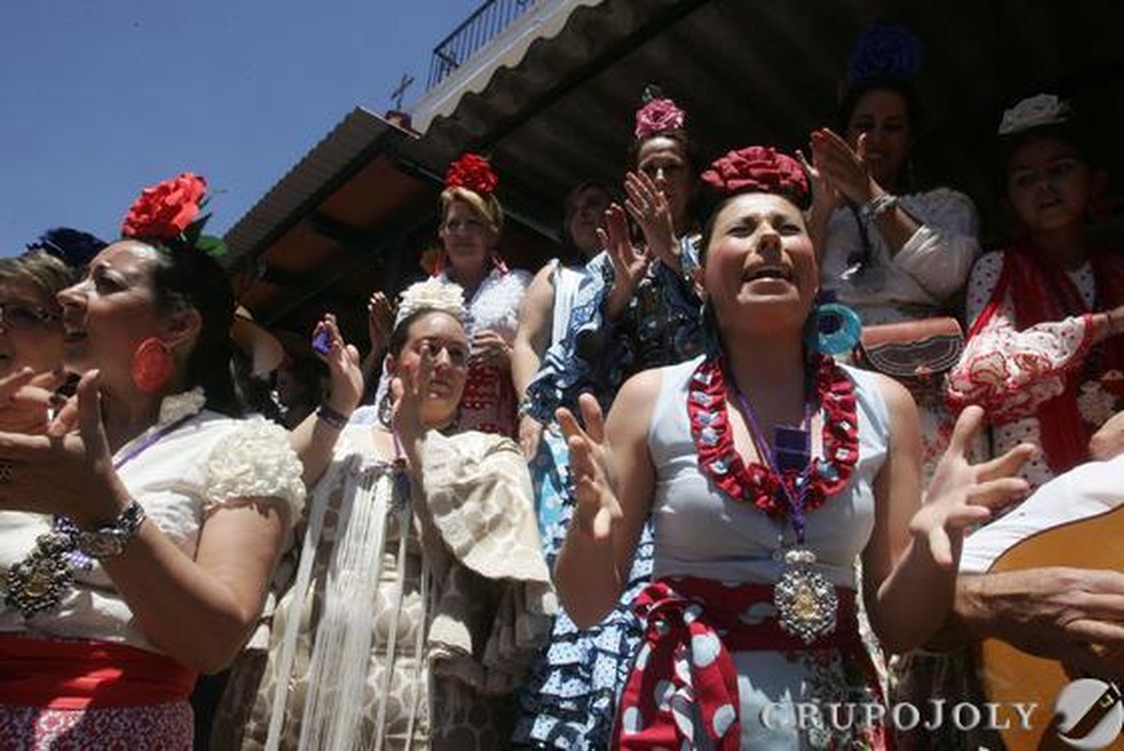 La emoción se palpa en cada rincón de la aldea. Una romera, junto a un nutrido grupo de mujeres que acompañan con palmas, canta al Simpecado al paso de la hermandad de Jerez

Foto: Pascual
