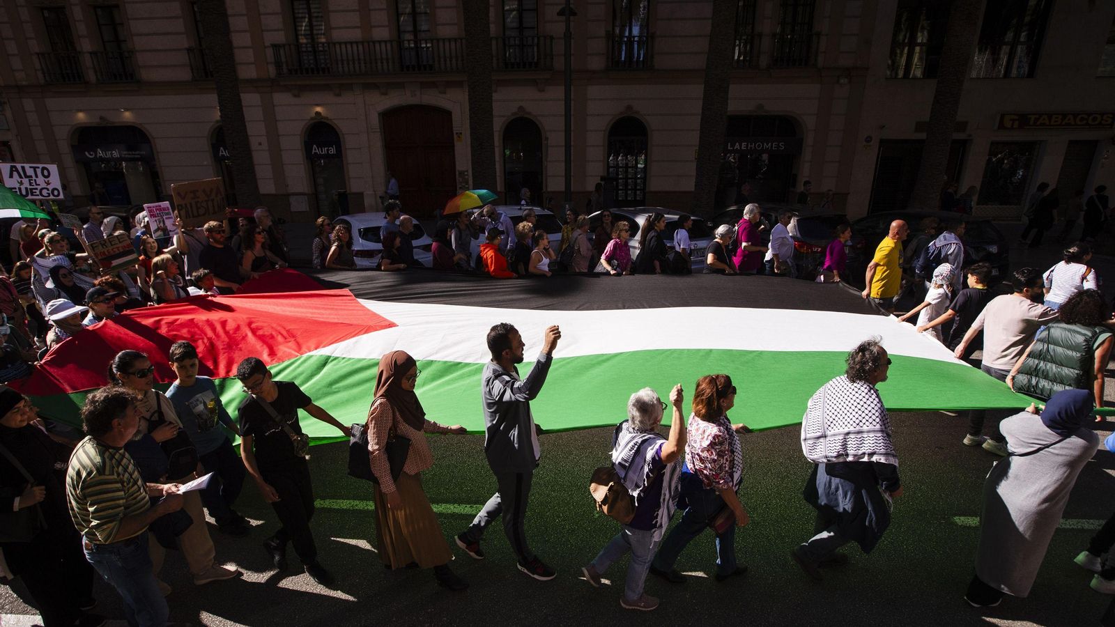Varias personas portan una bandera de Palestina.
