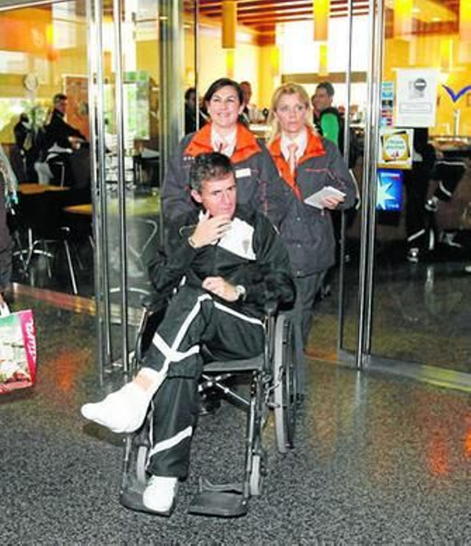 Alcaraz, en silla de ruedas, es ayudado por dos empleadas antes de pasar el control del AVE, ayer. Alcaraz, en silla de ruedas, es ayudado por dos empleadas antes de pasar el control del AVE, ayer.