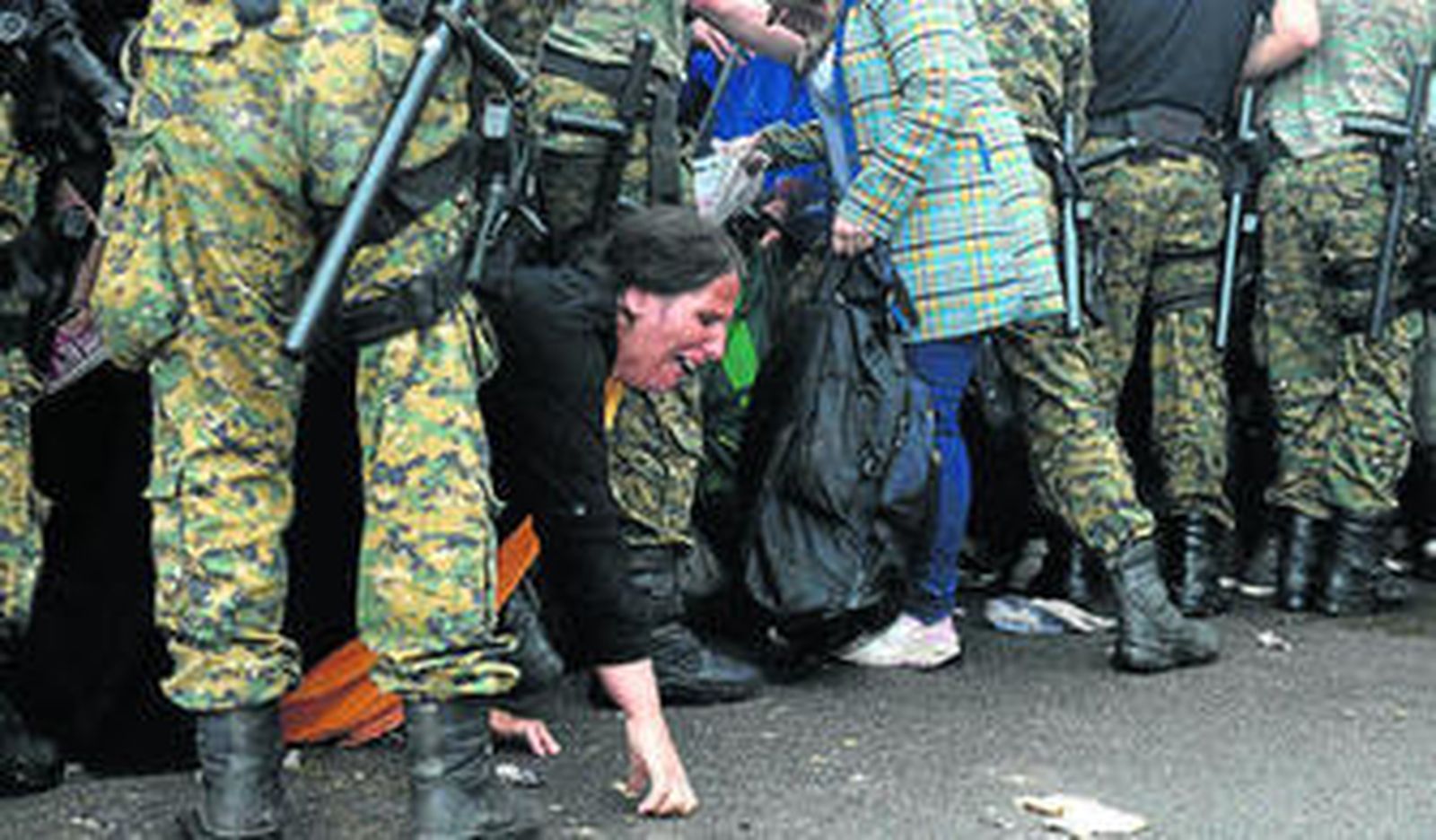 Refugiados intentan pasar una barrera de policías para subir a un autobús ayer en la localidad macedonia de Gevgelija.