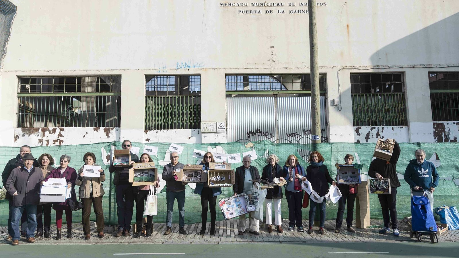 Los asistentes con sus obras de denuncia antes de colocarlas en la valla del antiguo mercado.