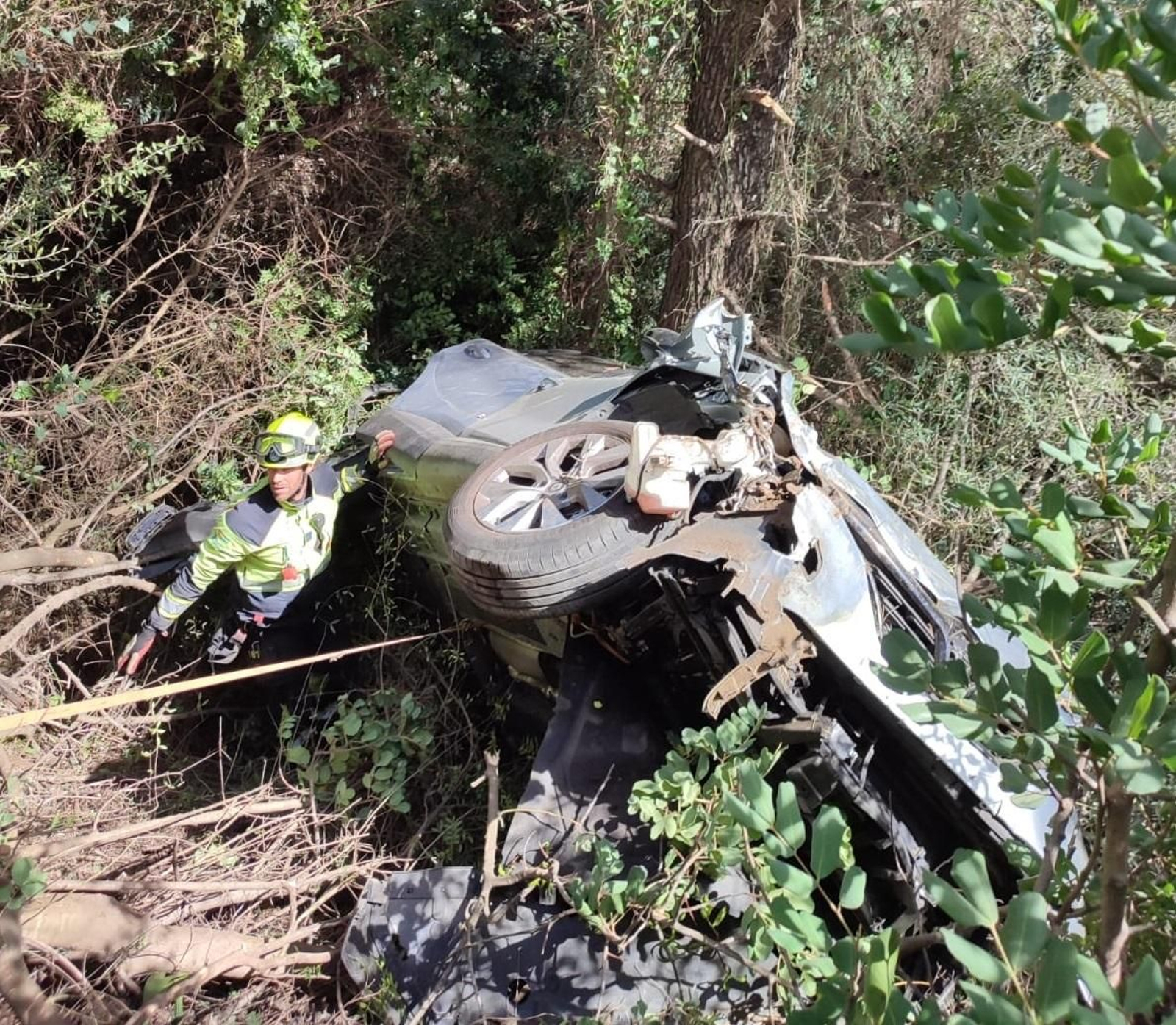 Uno de los operarios junto al vehículo siniestrado en Marbella