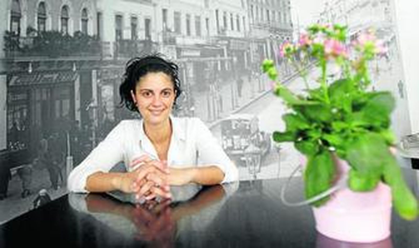 Pamela Córdoba, gerente de La Caña D'España, con una foto antigua de Claudio Marcelo de fondo.