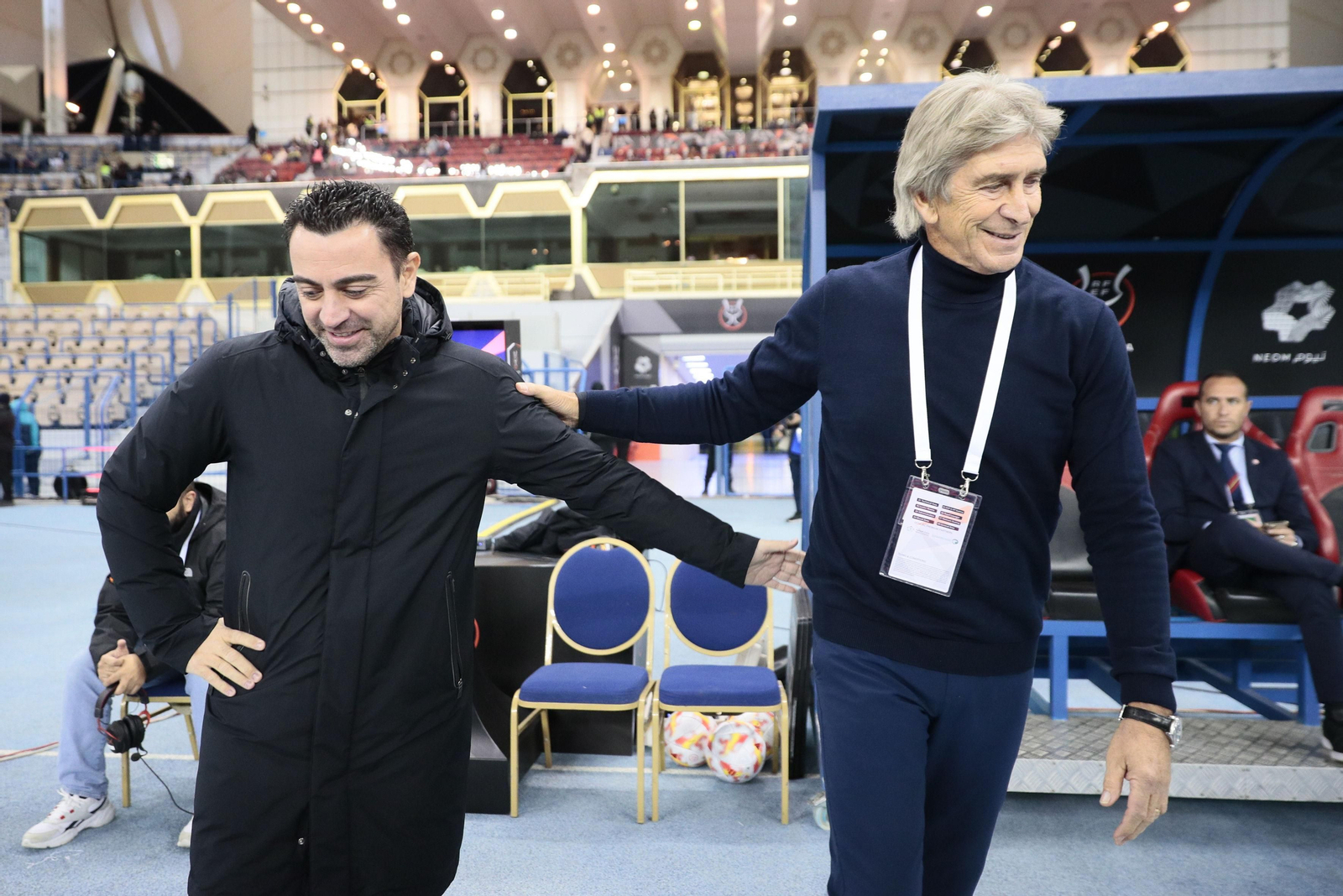 Pellegrini y Xavi se saludan.