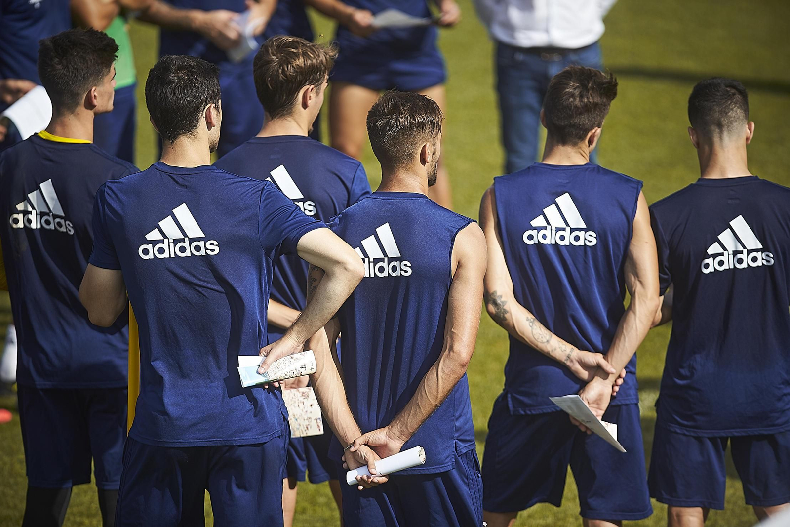 Varios jugadores del primer equipo atienden a la charla técnica durante un entrenamiento en El Rosal.