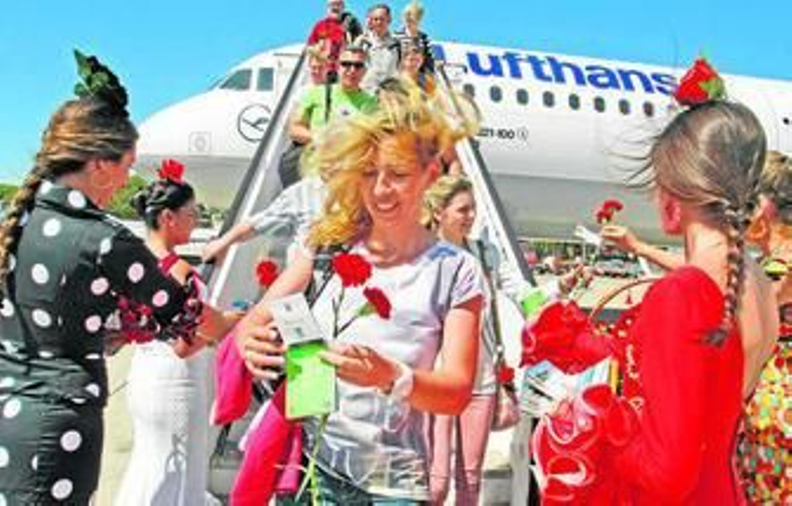 Los pasajeros son recibidos con claveles a su llegada al aeropueto de Jerez