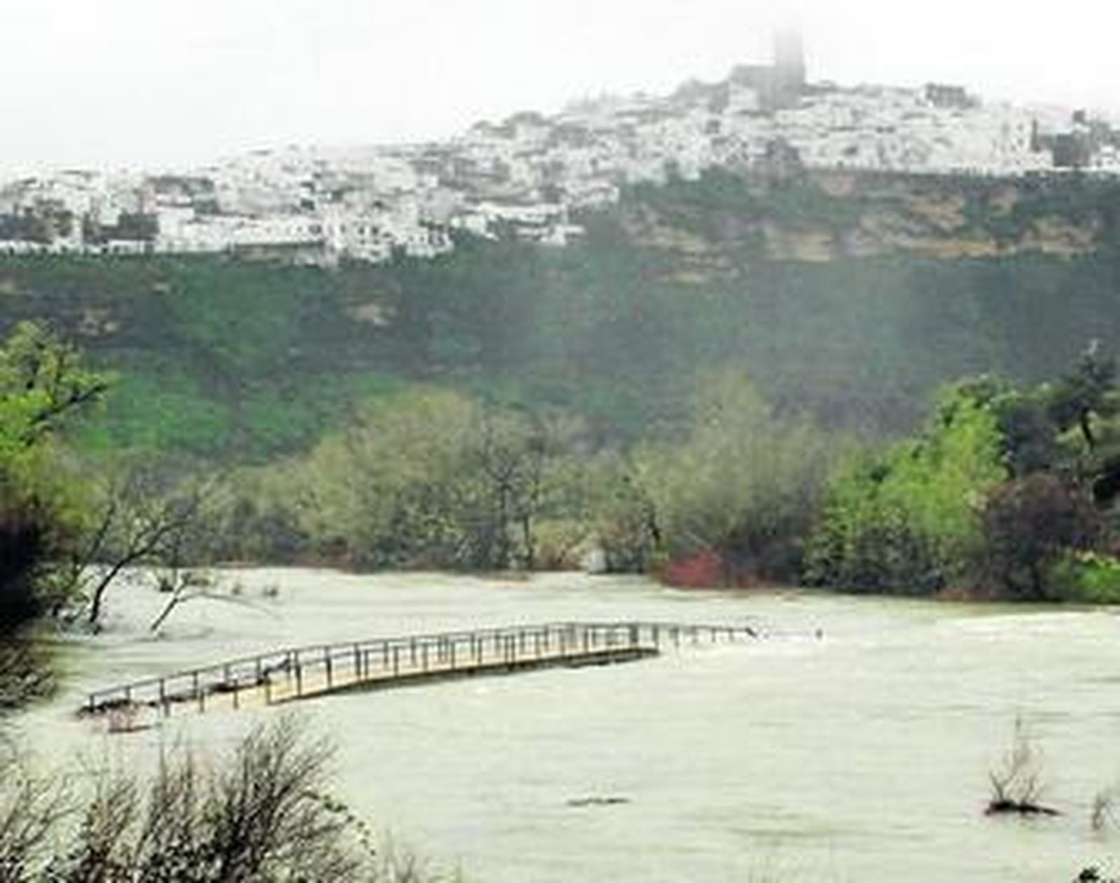 El caudaloso Guadalete, a su paso por Arcos, ayer, desdibujando puentes y pasarelas por el torrente.