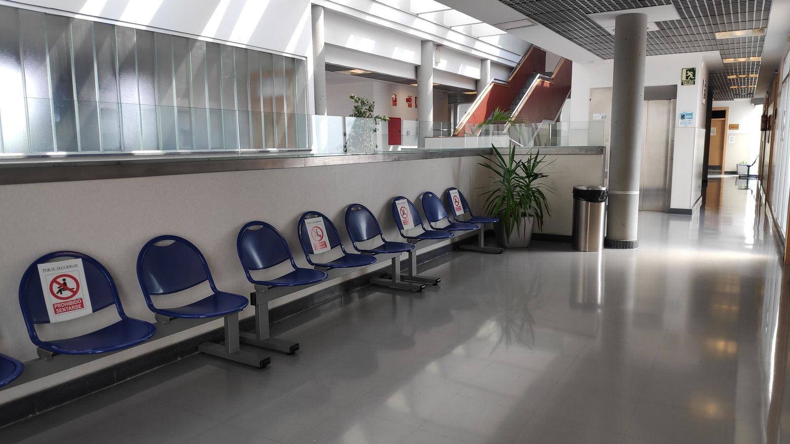 Una sala de espera vacía y con carteles que prohíben el uso de algunos asientos para mantener la distancia de seguridad.