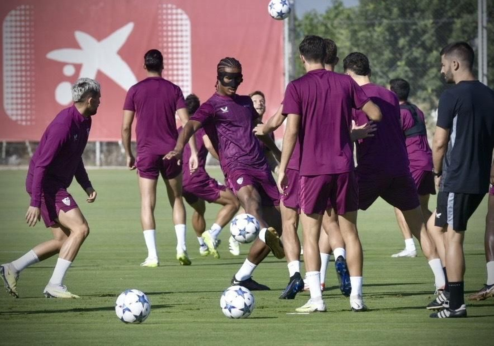 Badé, en medio de un rondo con su máscara, entre Januzaj y Ocampos.