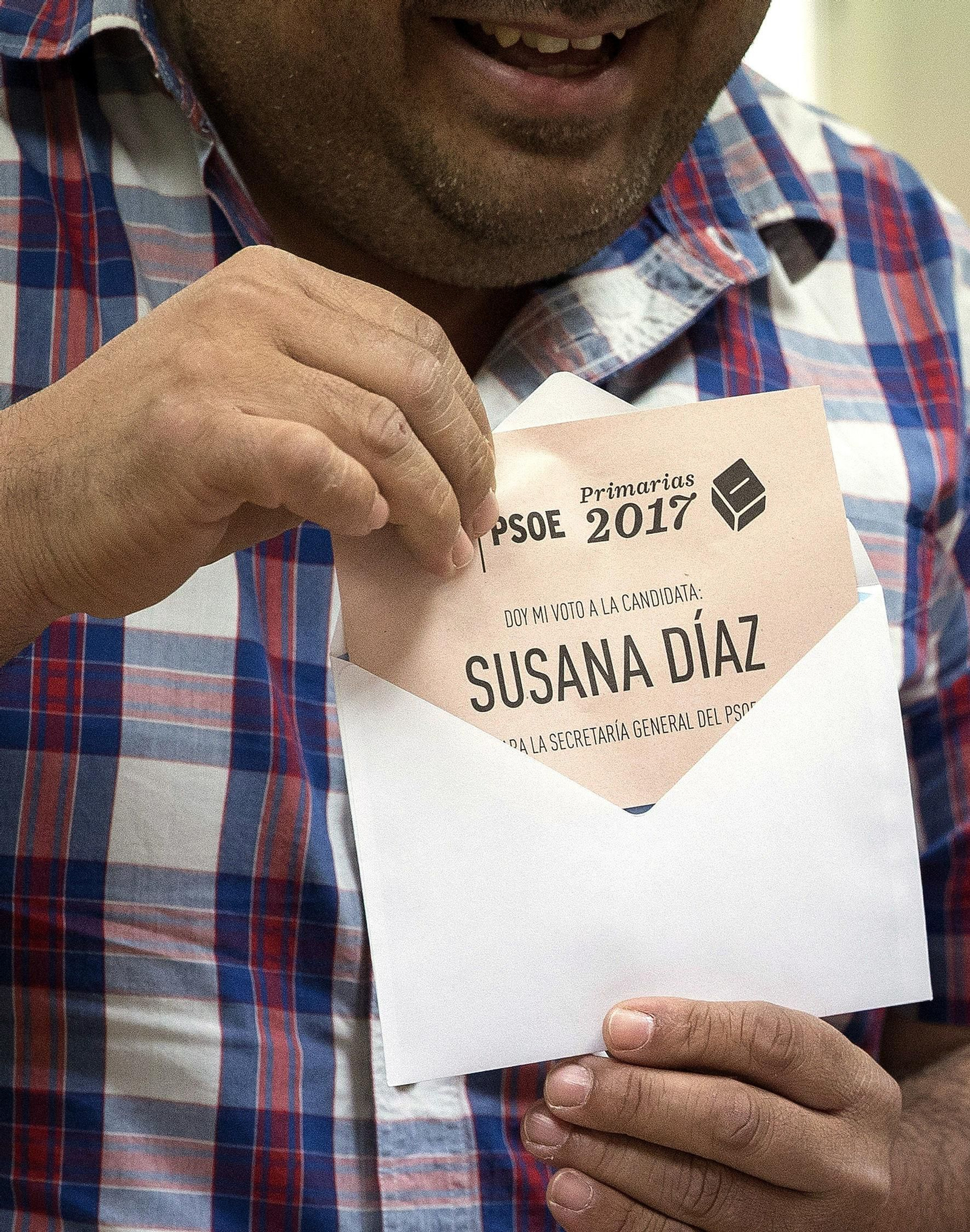 Un afiliado favorable a Susana Díaz guarda su papeleta en el sobre antes de votar.