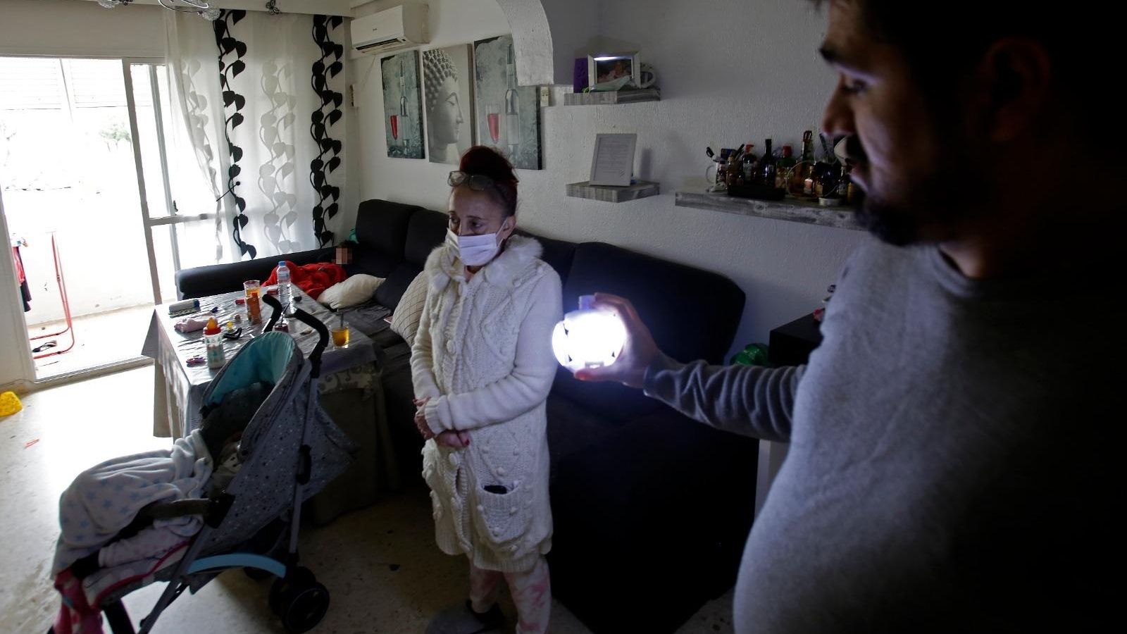 Antonio Marín se ilumina con una lámpara de pilas en su casa.