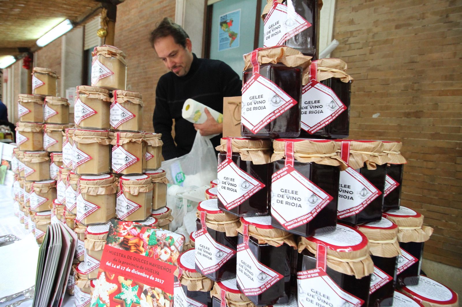 Tarros con los patés y confituras elaboradas por la firma El Monumento, durante la última muestra navideña de productos artesanales de la Diputación. Al fondo, el propietario, Teo Castilla.
